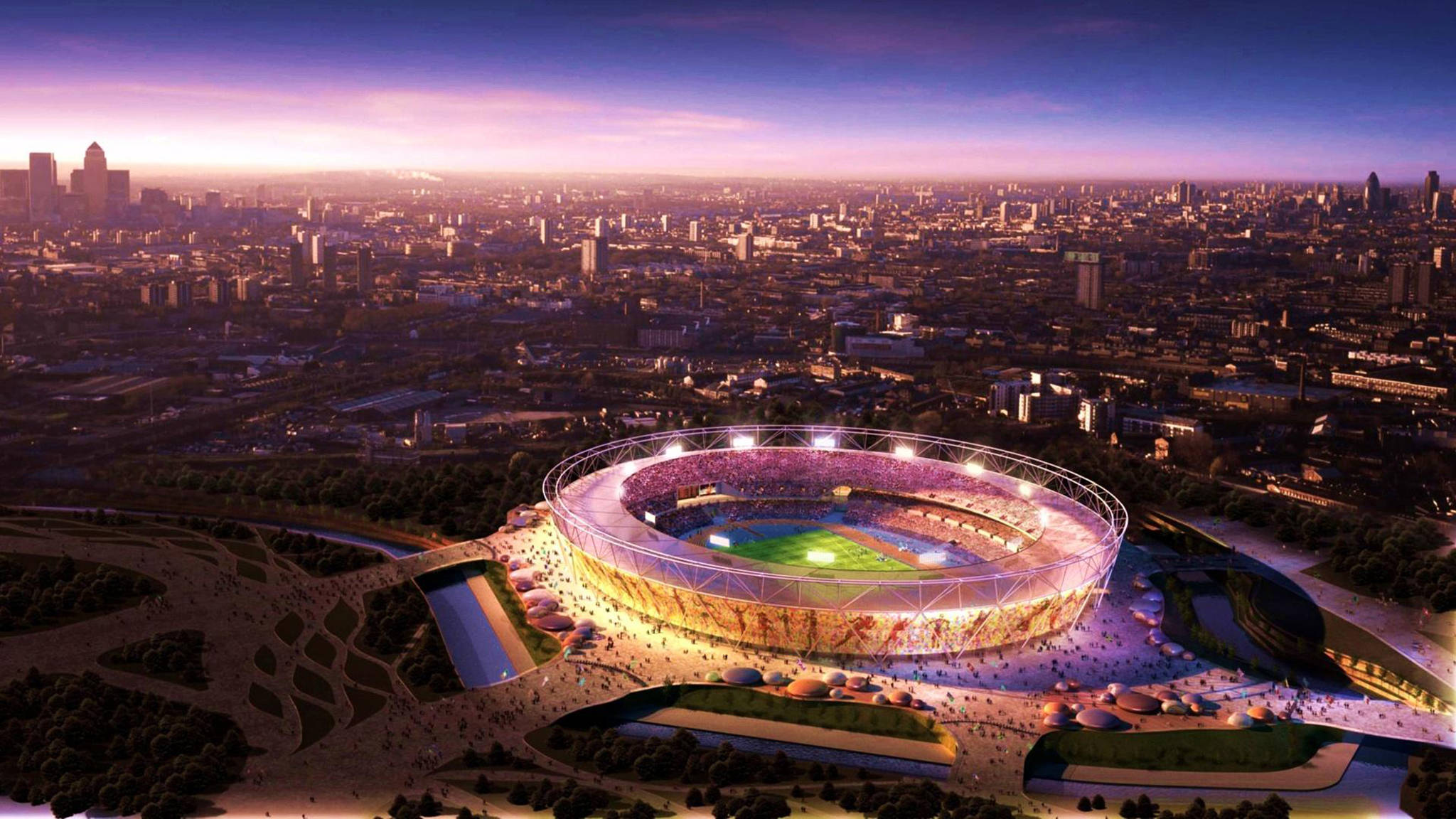 Stadium 桌布 壁紙 — 一個閃爍的現代體育場沐浴在金色光芒中，主宰著暮色中廣闊的城市天際線。