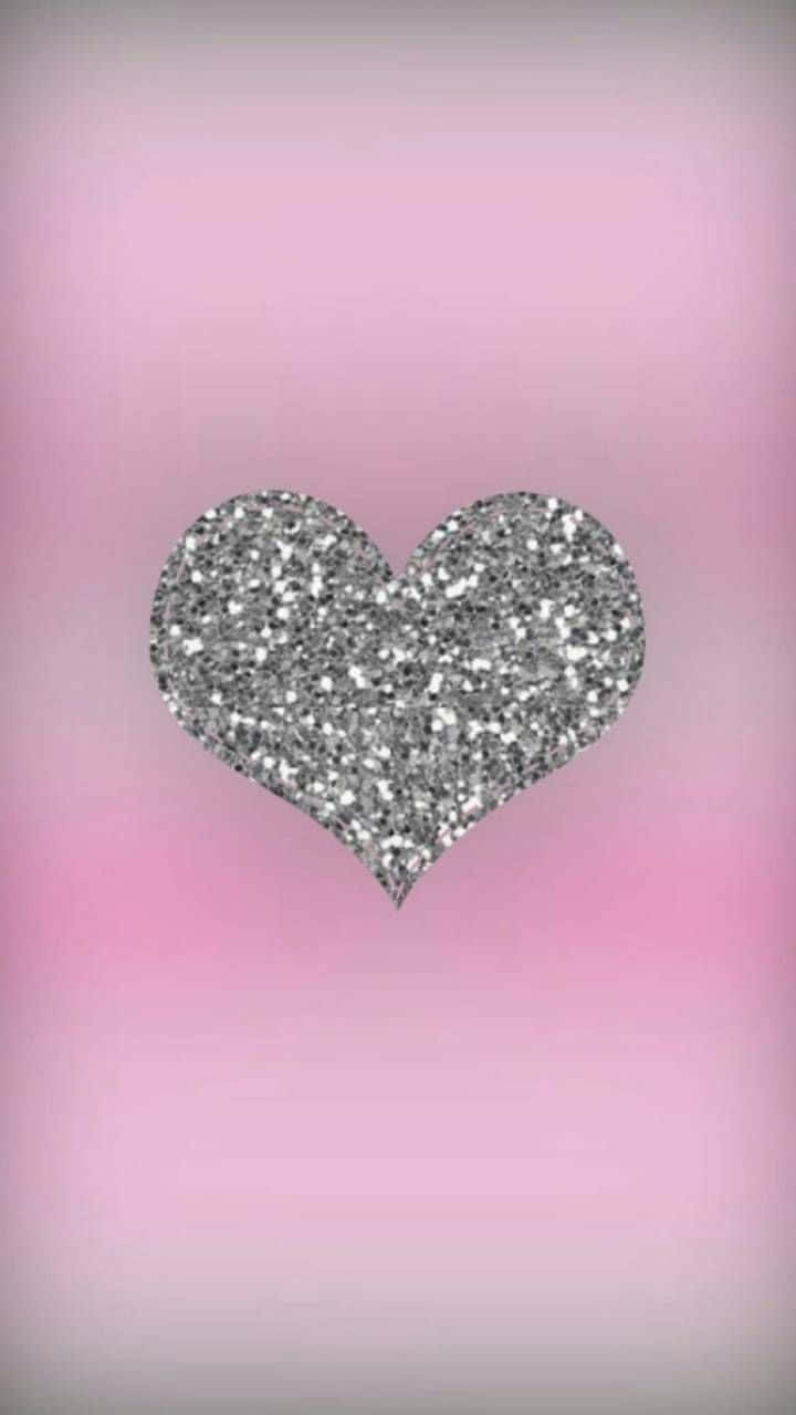 Glitter Pink Hearts 桌布 壁紙 — 一個閃爍的銀色亮片心形，置於柔和漸層粉紅色背景中央。