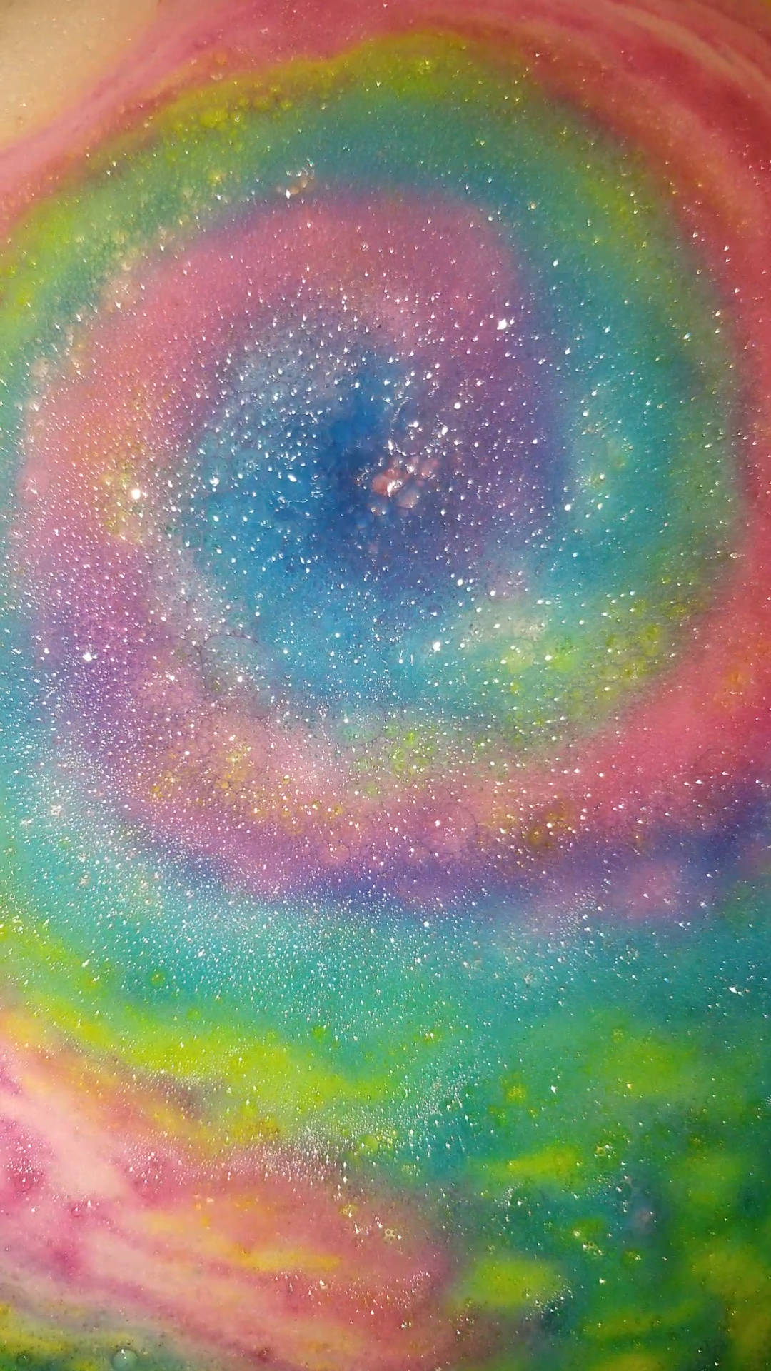 Screen 桌布 壁紙 — 一個閃爍粉彩顏色的旋轉星系從宇宙中心向外輻射，形成迷人的抽象圖案。