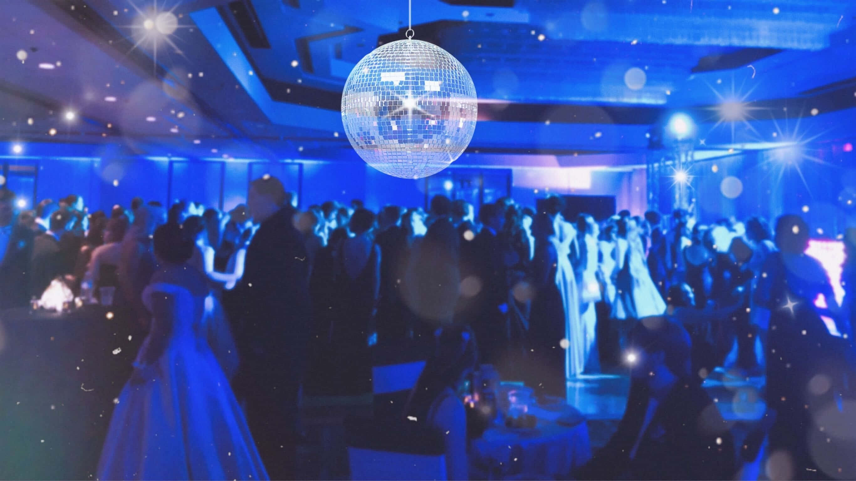 Party 桌布 壁紙 — 一個閃閃發光的迪斯科球懸掛在一個熱鬧的舞廳中，人群在充滿活力的藍色燈光下跳舞。
