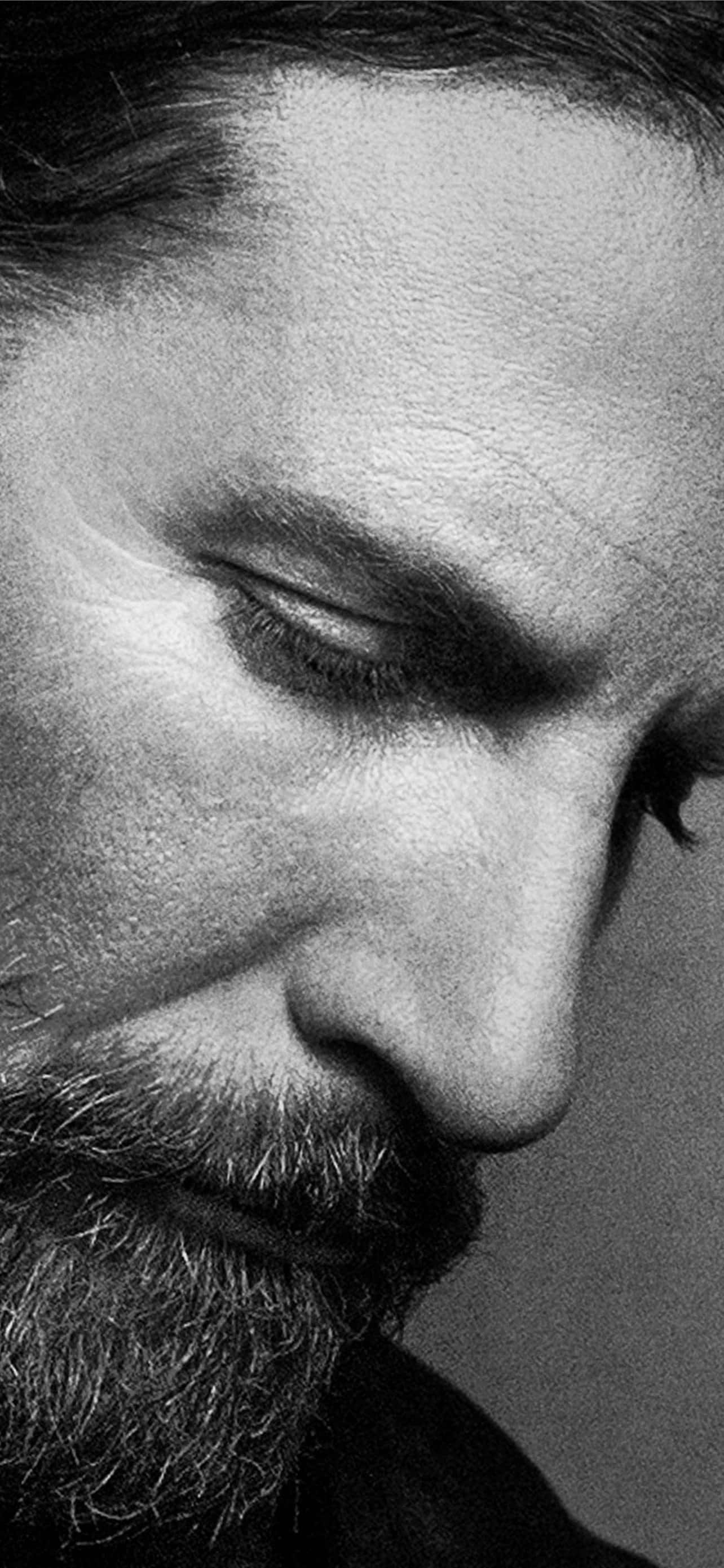 actor 桌布 壁紙 — 一個閉上眼睛、鬍鬚有紋理的男人的黑白特寫肖像，顯示出深深的皺紋和柔和的光線。