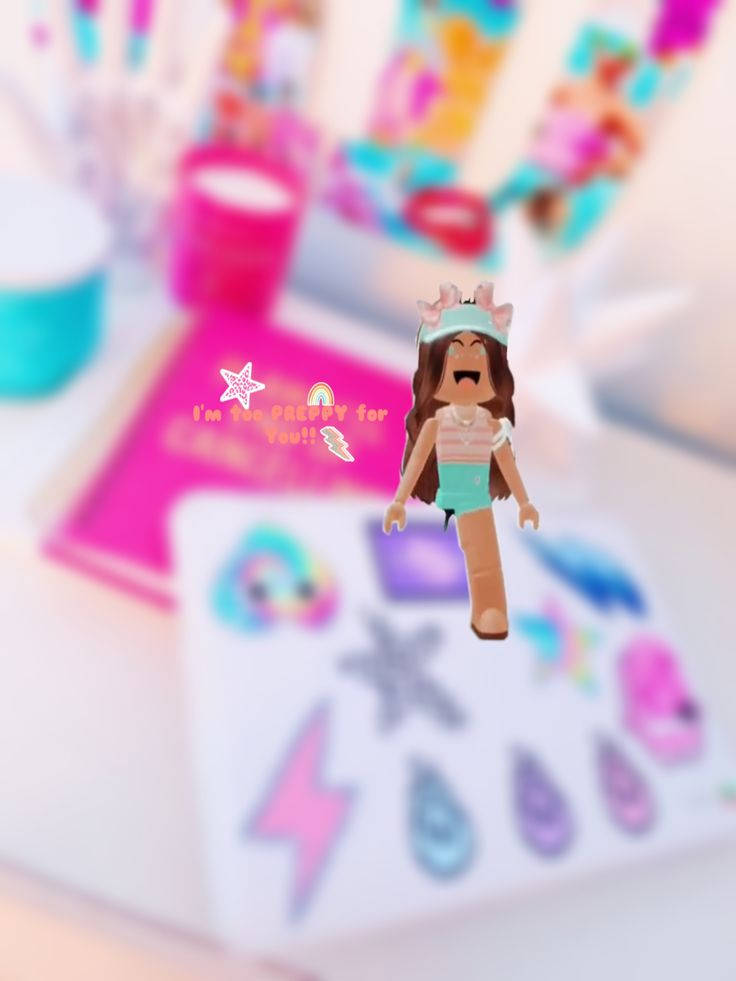 一個戴著皇冠的 Roblox 頭像在一個有貼紙和顏料的手工桌上微笑。 — 粉紅學院風 壁紙