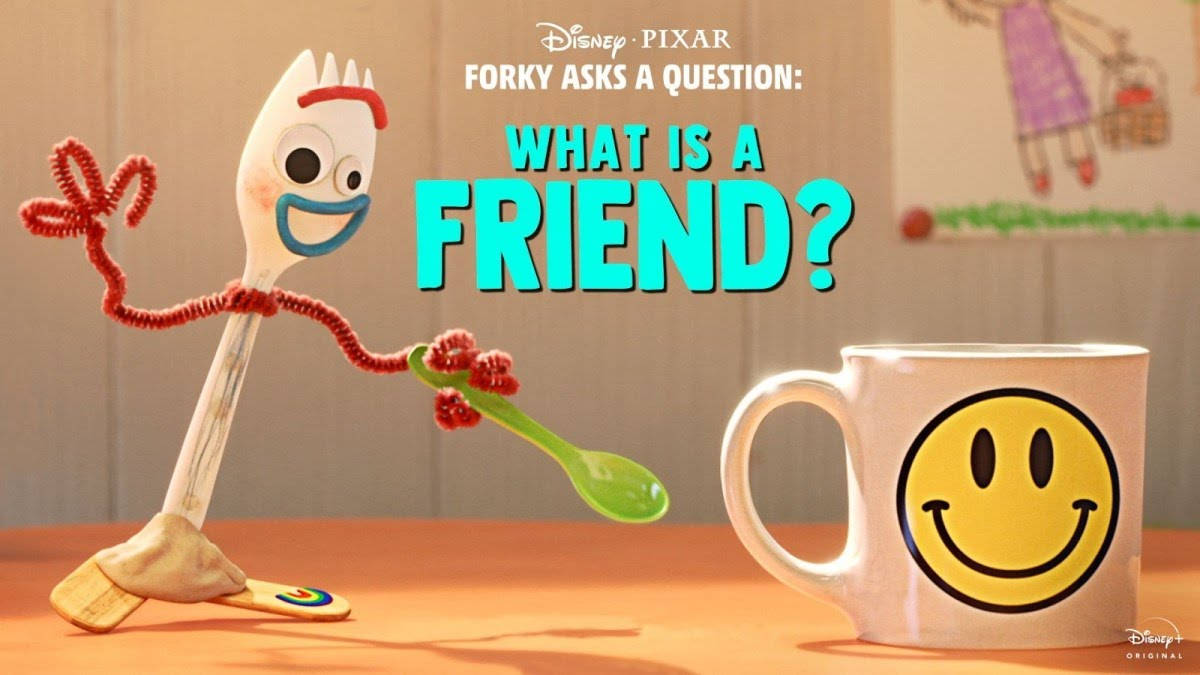 Forky 桌布 壁紙 — 一個開心的Forky玩具，用通渠刷做手臂，在木桌上一個笑臉杯旁邊揮手。