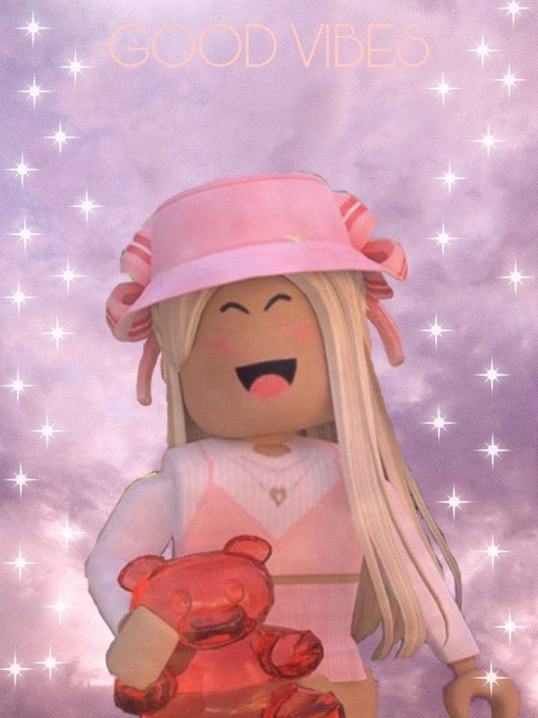 美學 Roblox 女孩 桌布 壁紙 — 一個開心的Roblox頭像，金髮戴粉紅色帽子，在閃爍的紫色天空下抱著紅色泰迪熊，並有'GOOD VIBES'字樣。