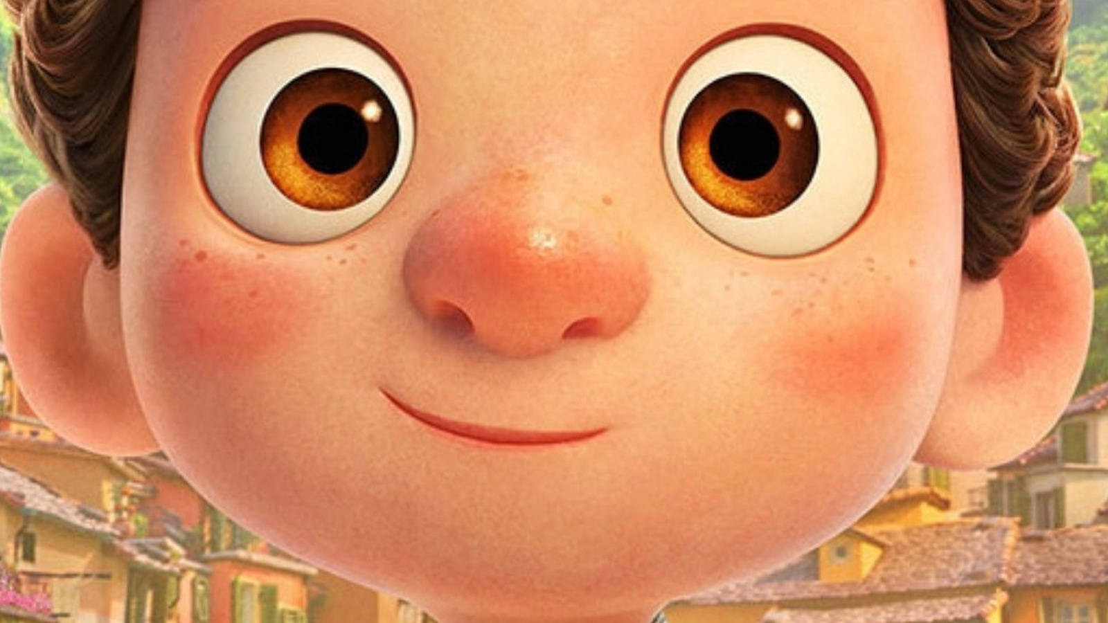Pixar Luca 桌布 壁紙 — 一個開心的動畫男孩特寫，擁有巨大的棕色眼睛和玫瑰色臉頰，在色彩繽紛的村莊背景下溫暖地微笑。