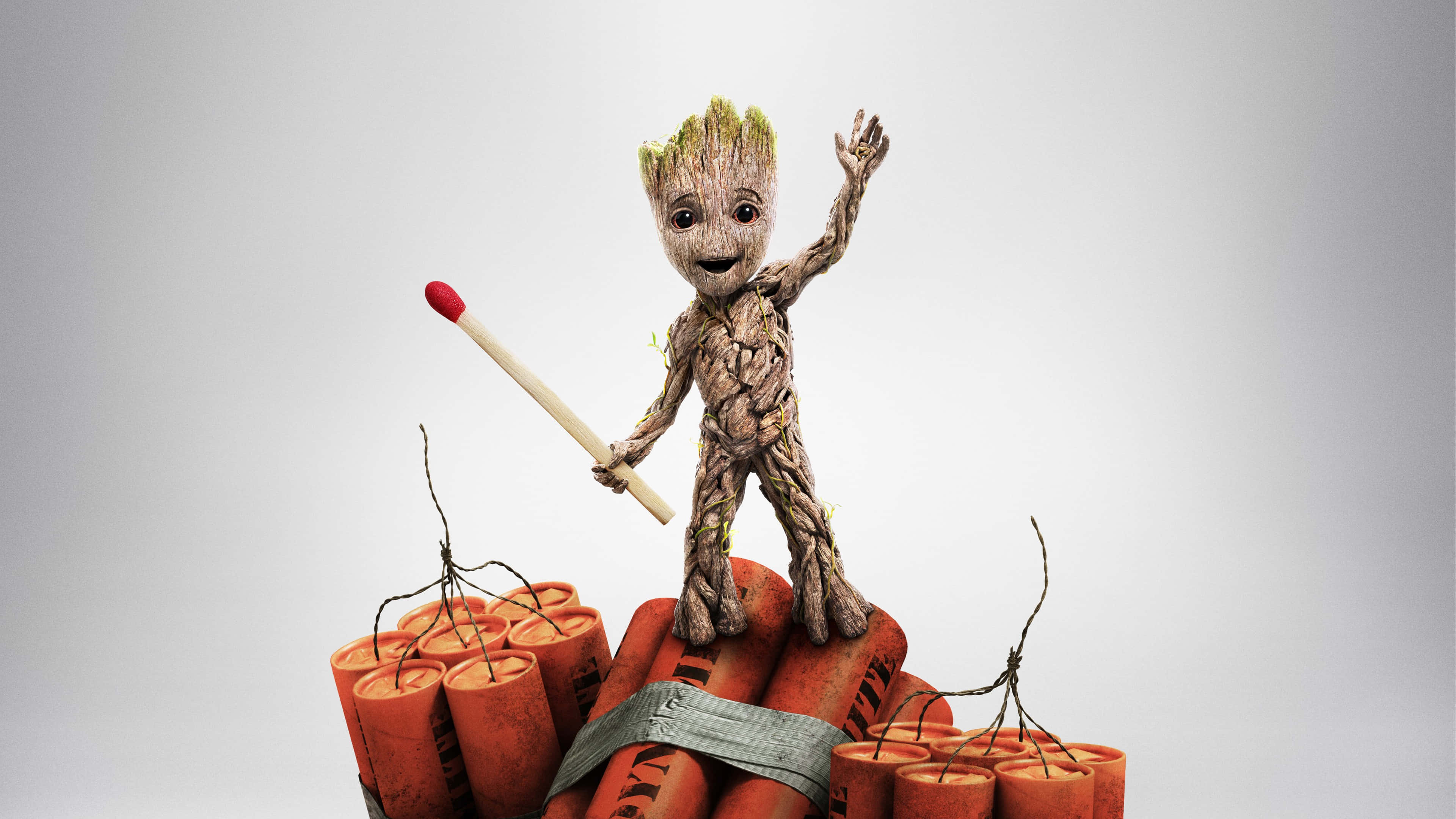 Guardians Of The Galaxy 2 桌布 壁紙 — 一個開心的格魯特寶寶站在一捆炸藥上，拿著一根火柴，背景是純灰色。