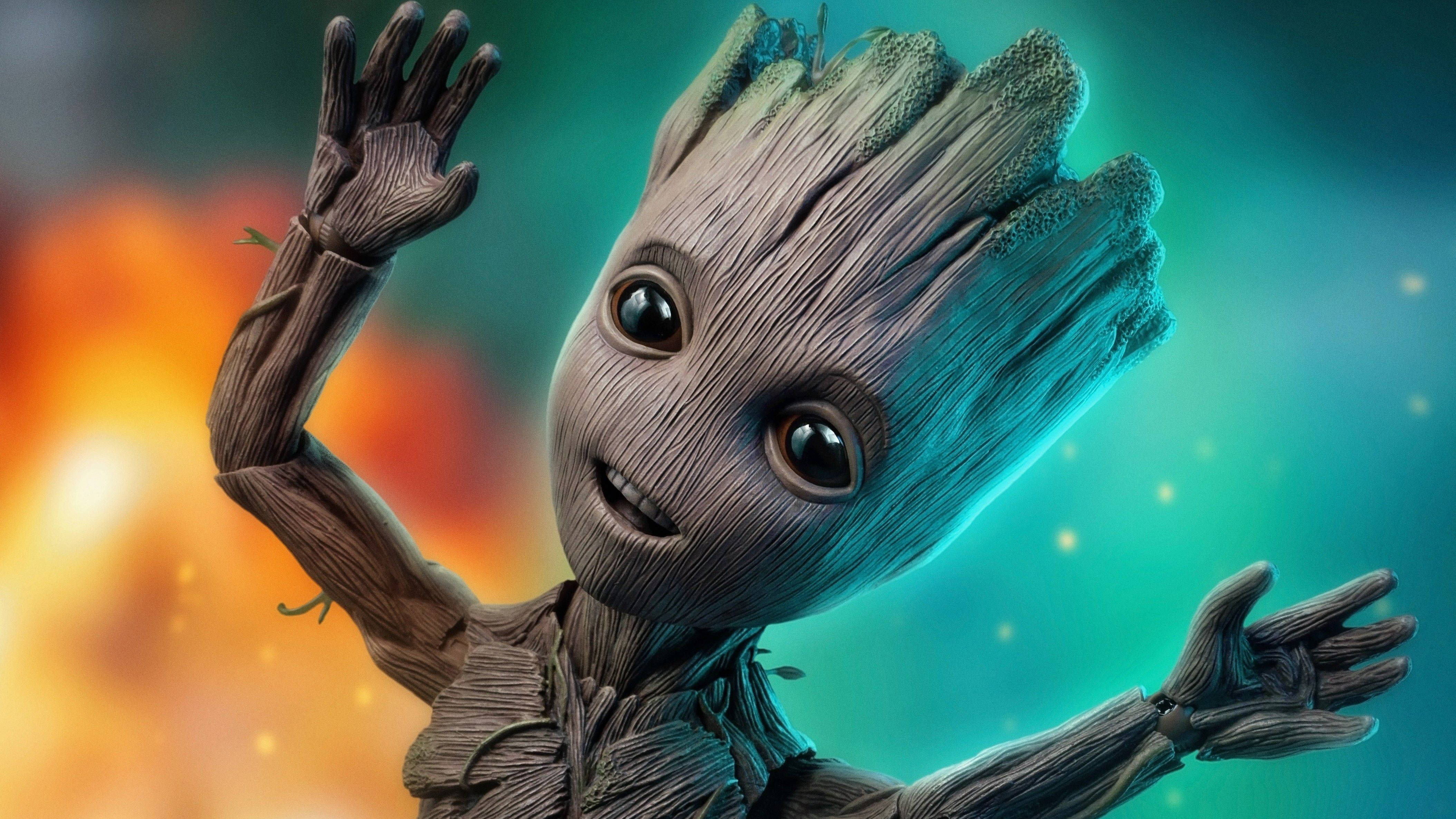 4K Guardians Of The Galaxy 桌布 壁紙 — 一個開心的樹狀嬰兒，有大眼睛和張開的手臂，在熾熱橙色和發光青綠色的宇宙背景下揮手。