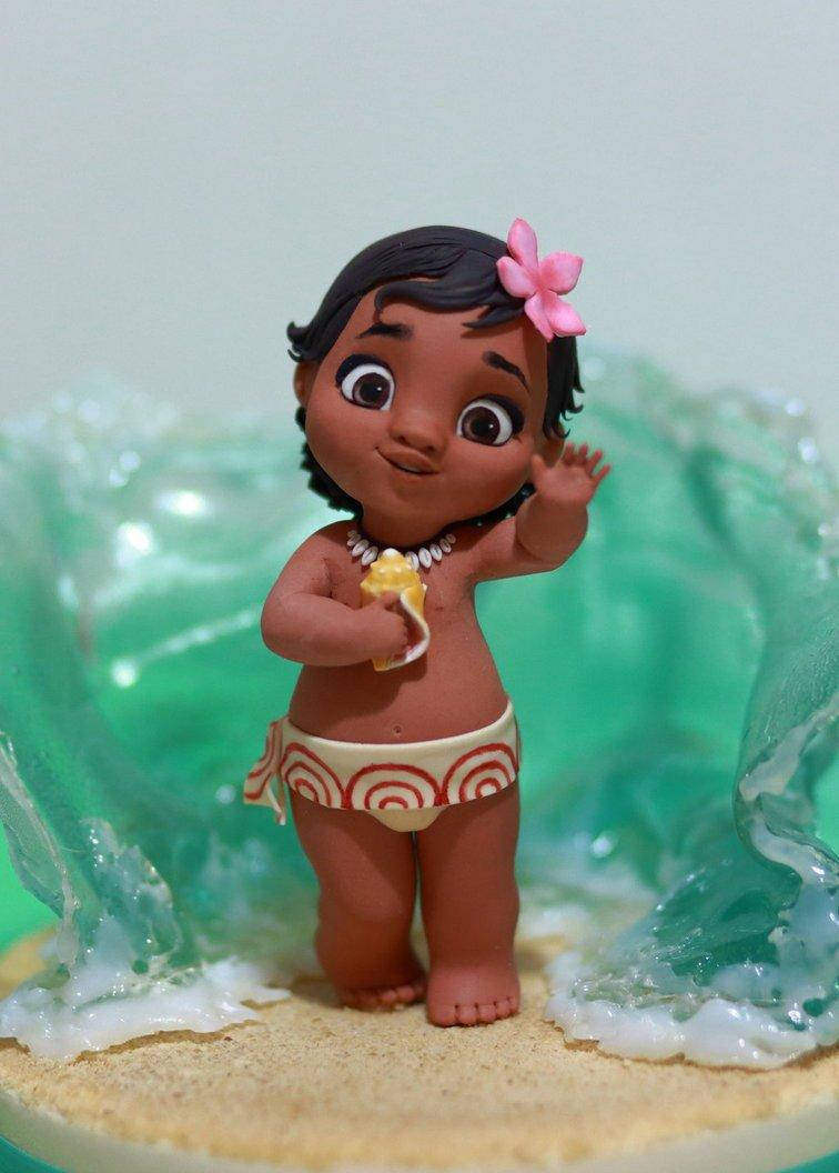 Baby Moana 桌布 壁紙 — 一個開心的莫阿娜公仔在藍綠色波浪背景下揮手，同時拿著一根香蕉。