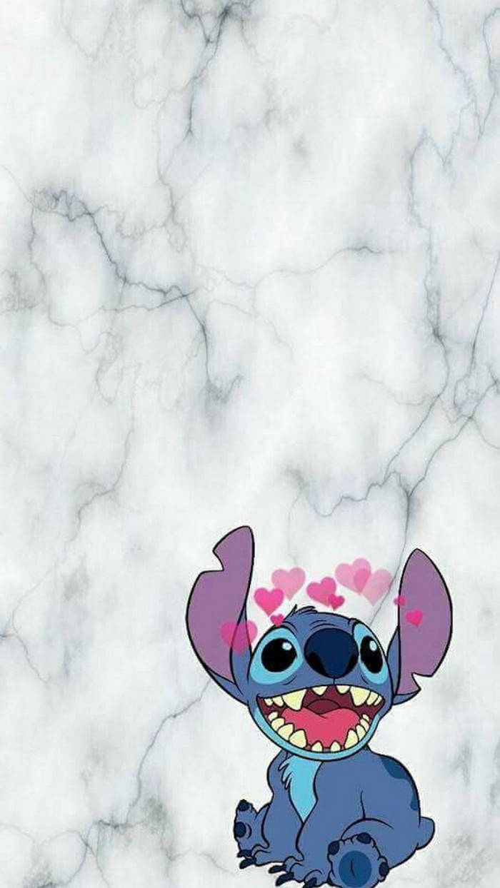 kawaii stitch 桌布 壁紙 — 一個開心的藍色卡通外星人，頭頂有心形漂浮，坐在白色大理石背景上。