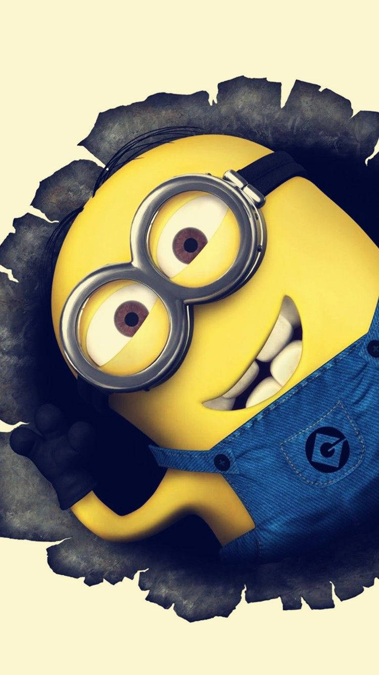 Animated 桌布 壁紙 — 一個開心的黃色Minion戴著護目鏡和藍色吊帶褲，從一個破洞中探頭出來，露出燦爛的笑容。
