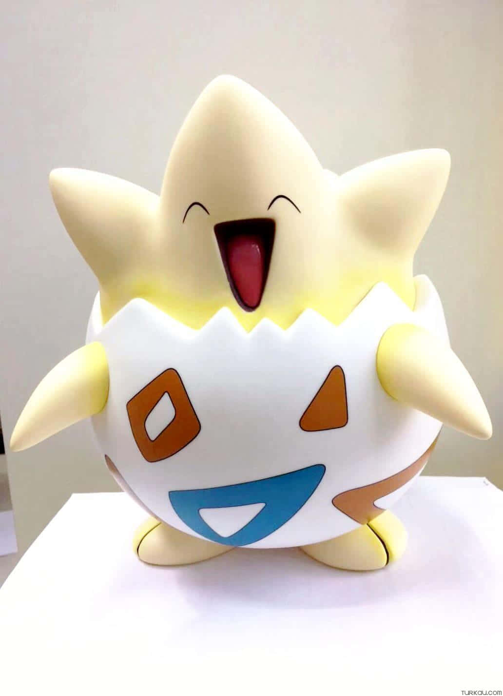 Pokemon Toys 桌布 壁紙 — 一個開心的黃色和白色寶可夢公仔，張大嘴巴，閉著眼睛，站在白色的表面上。