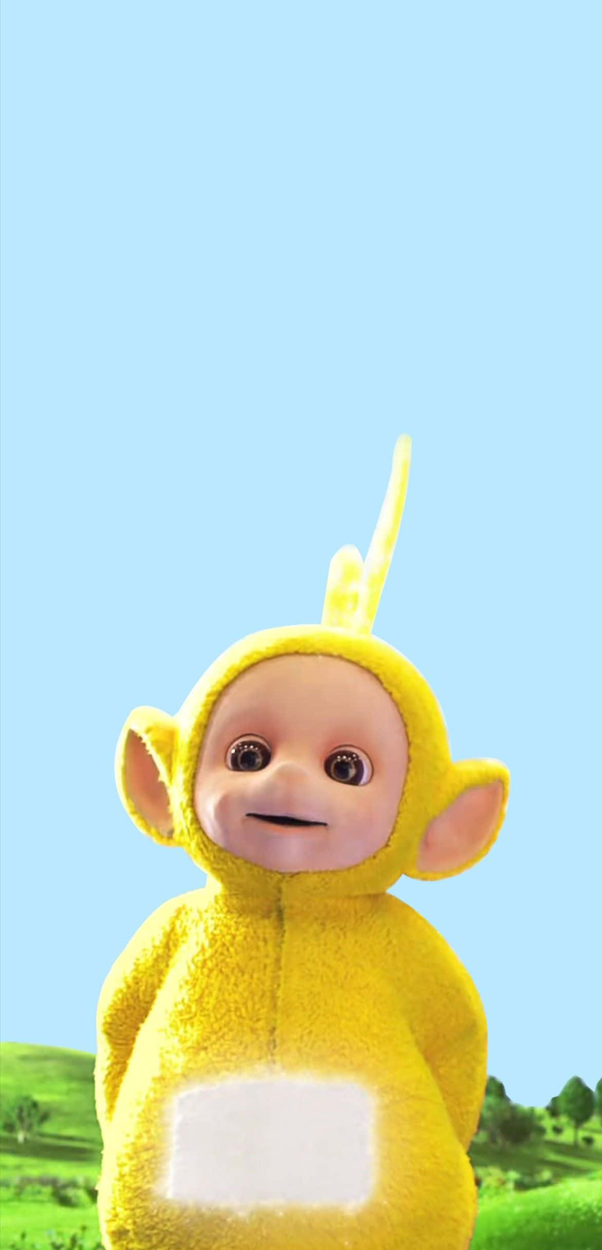 Teletubbies 桌布 壁紙 — 一個開心的黃色天線寶寶角色在明亮的藍天和下面的綠色山丘前微笑。