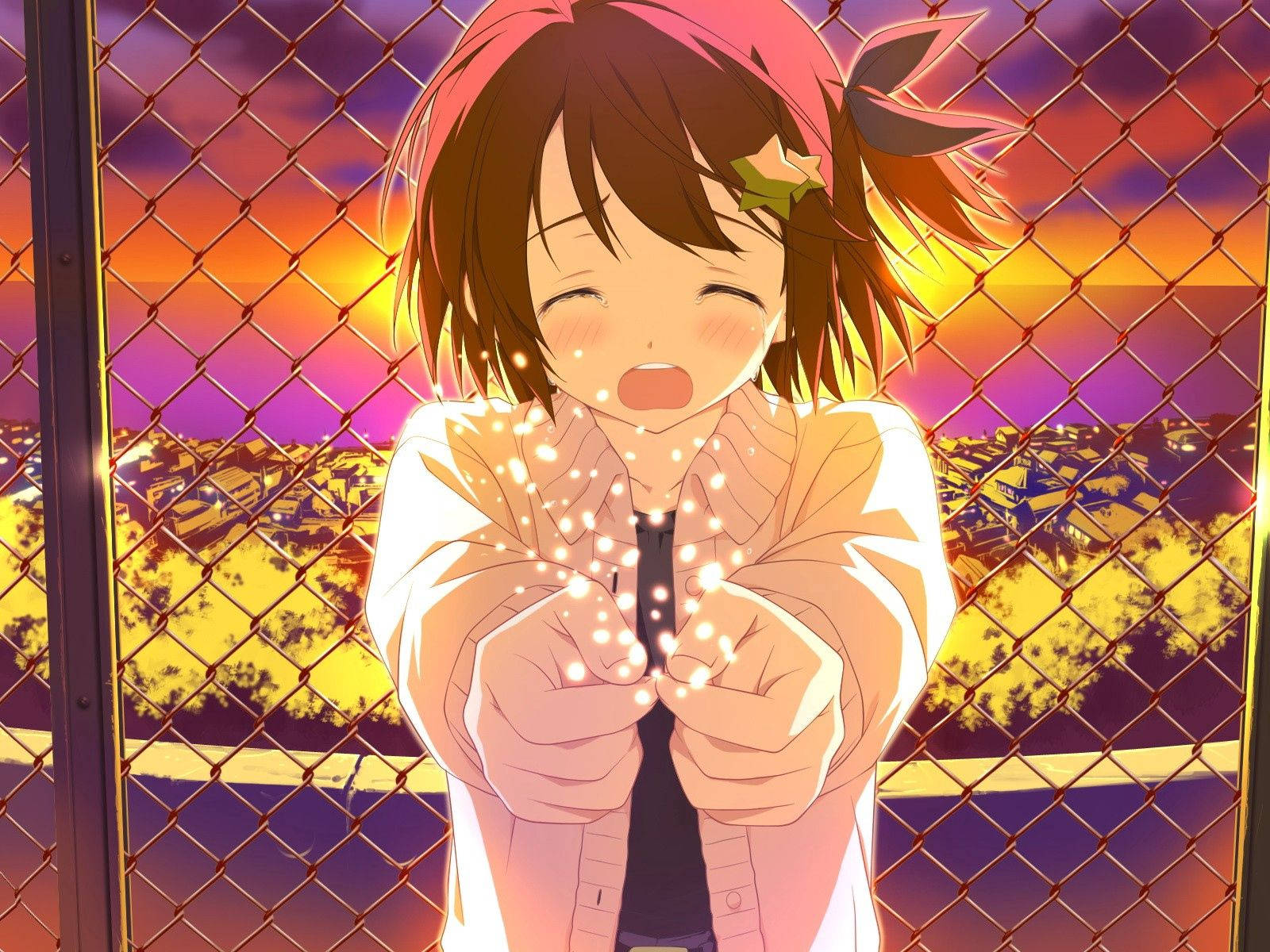 anime crying 桌布 壁紙 — 一個開朗的動漫女孩，棕色頭髮和星星髮夾，在鐵絲網圍欄後面燦爛地微笑，她捧著的手裡迸發出閃爍的光芒，映襯著充滿活力的日落天空。