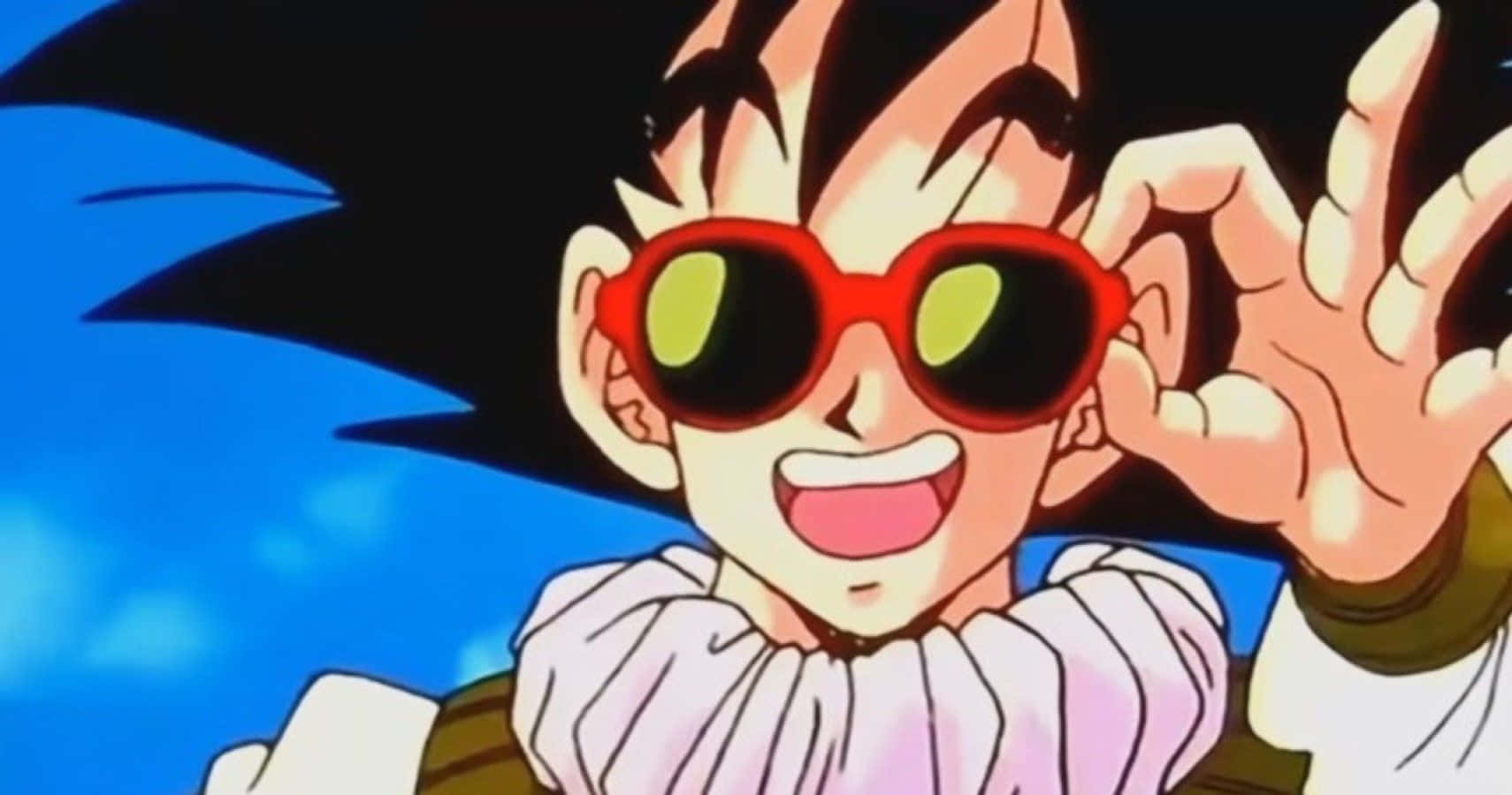 Funny Goku 桌布 壁紙 — 一個開朗的動漫男孩，黑色刺蝟頭，戴著紅色太陽眼鏡，在明亮的藍天下開心地揮手。