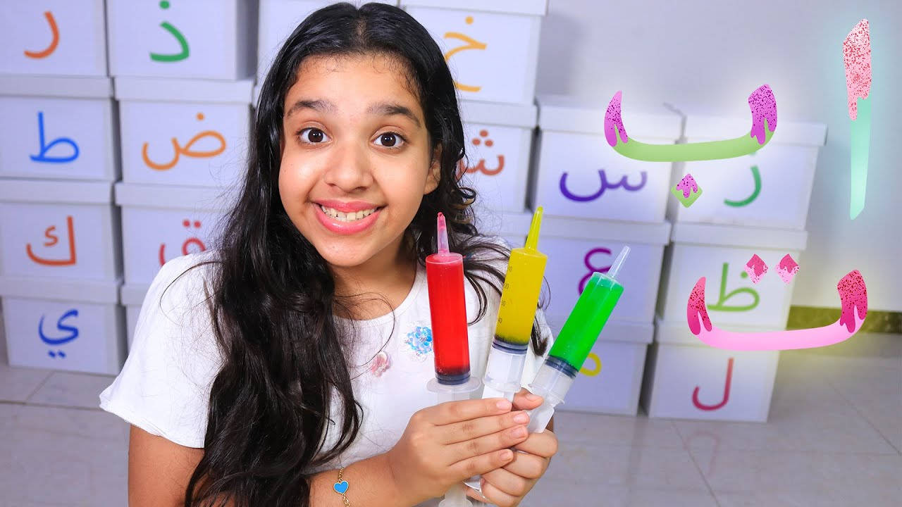 小女孩在阿拉伯字母信箱前手持彩色注射器。 — 小孩動圖 壁紙