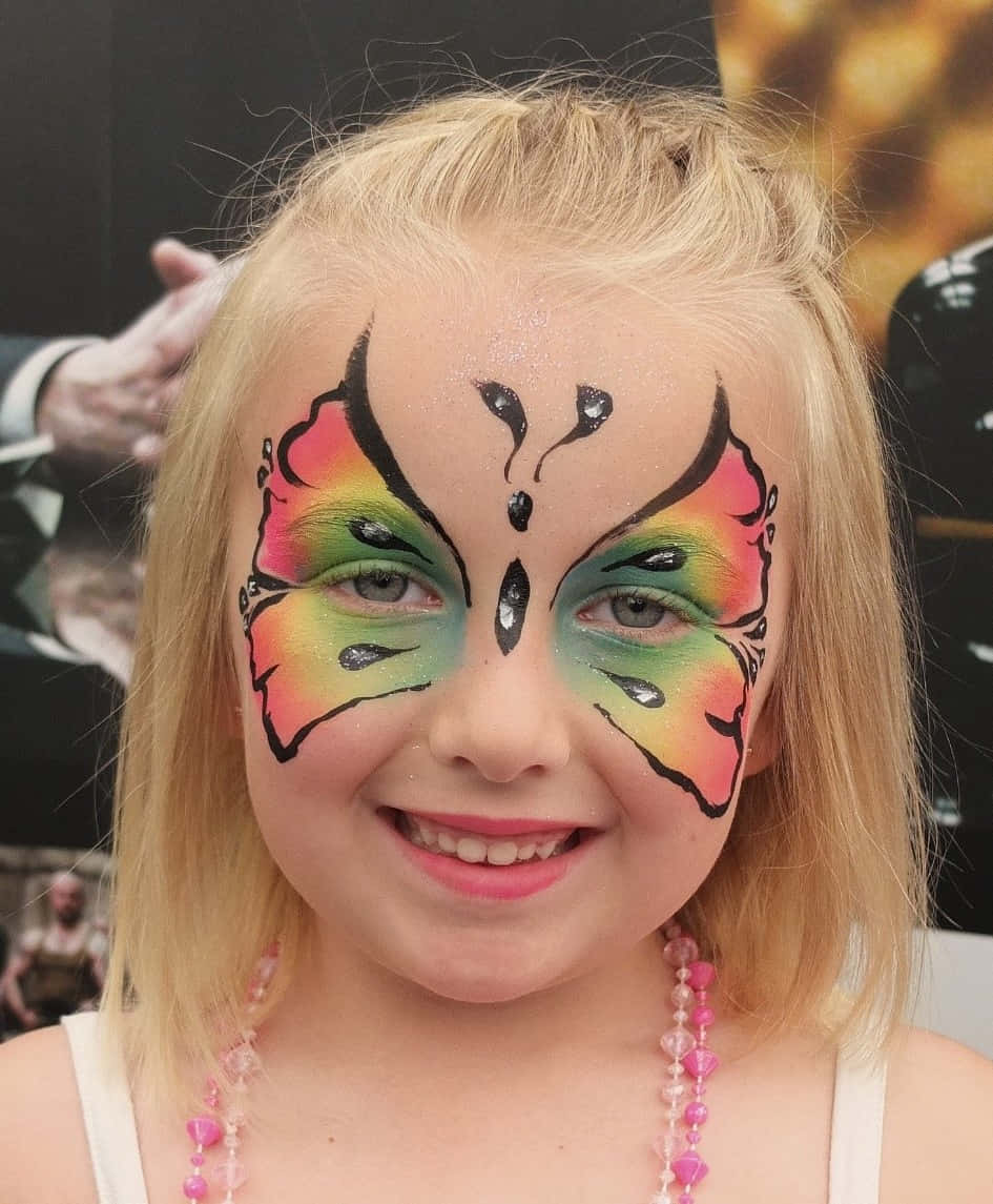 Butterfly Face Painting 桌布 壁紙 — 一個開朗的金髮小女孩，臉上塗著鮮豔的彩虹色蝴蝶彩繪，閃閃發光。
