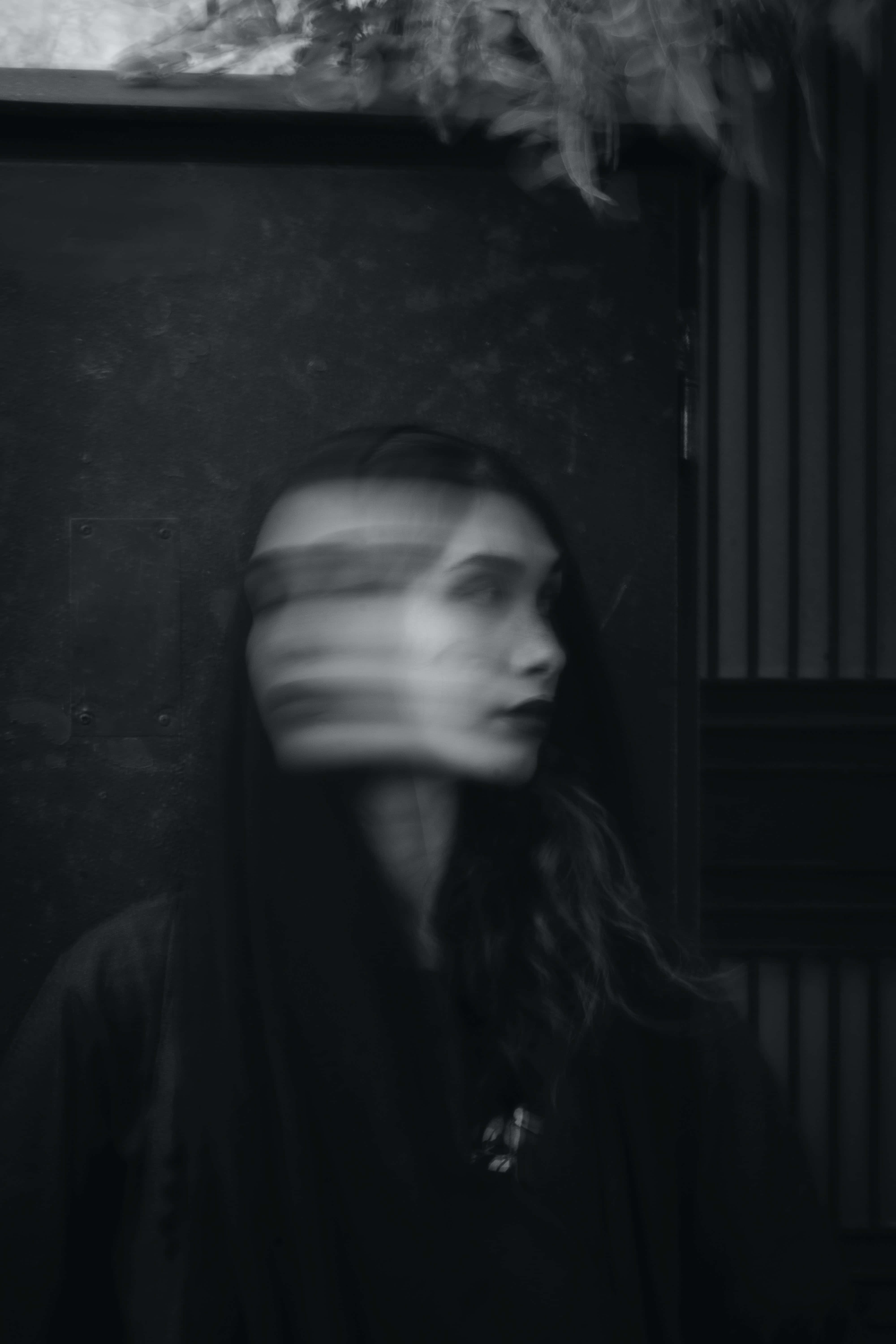 Confused 桌布 壁紙 — 一個陰暗房間中，頭頂有羽毛裝飾的模糊女性的單色肖像。