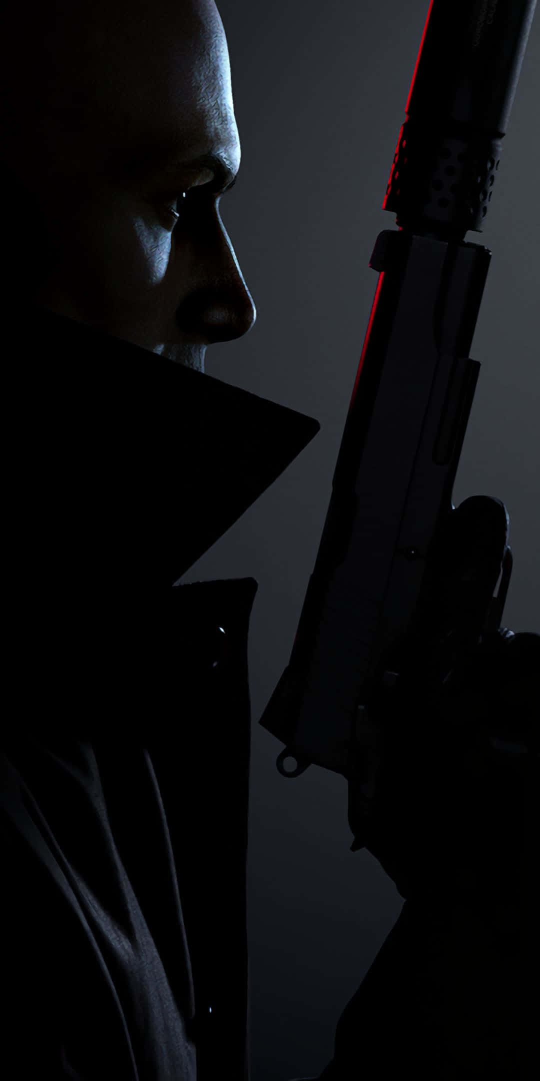 Pixel 3 Hitman Absolution 桌布 壁紙 — 一個陰暗的男人穿著風衣，在黑暗背景下拿著一把帶有紅色發光裝飾的手槍。