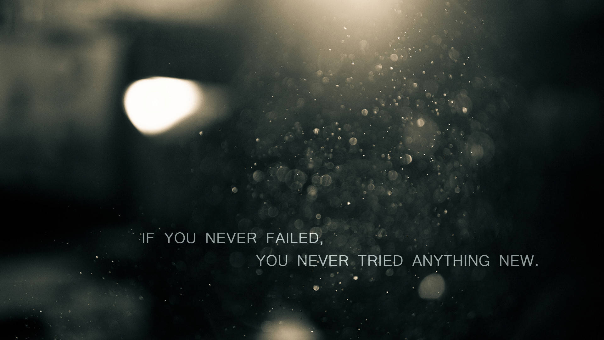 Motivation 桌布 壁紙 — 一個陰暗的背景，帶有漂浮的灰塵顆粒，被柔和的光芒和勵志文字照亮。
