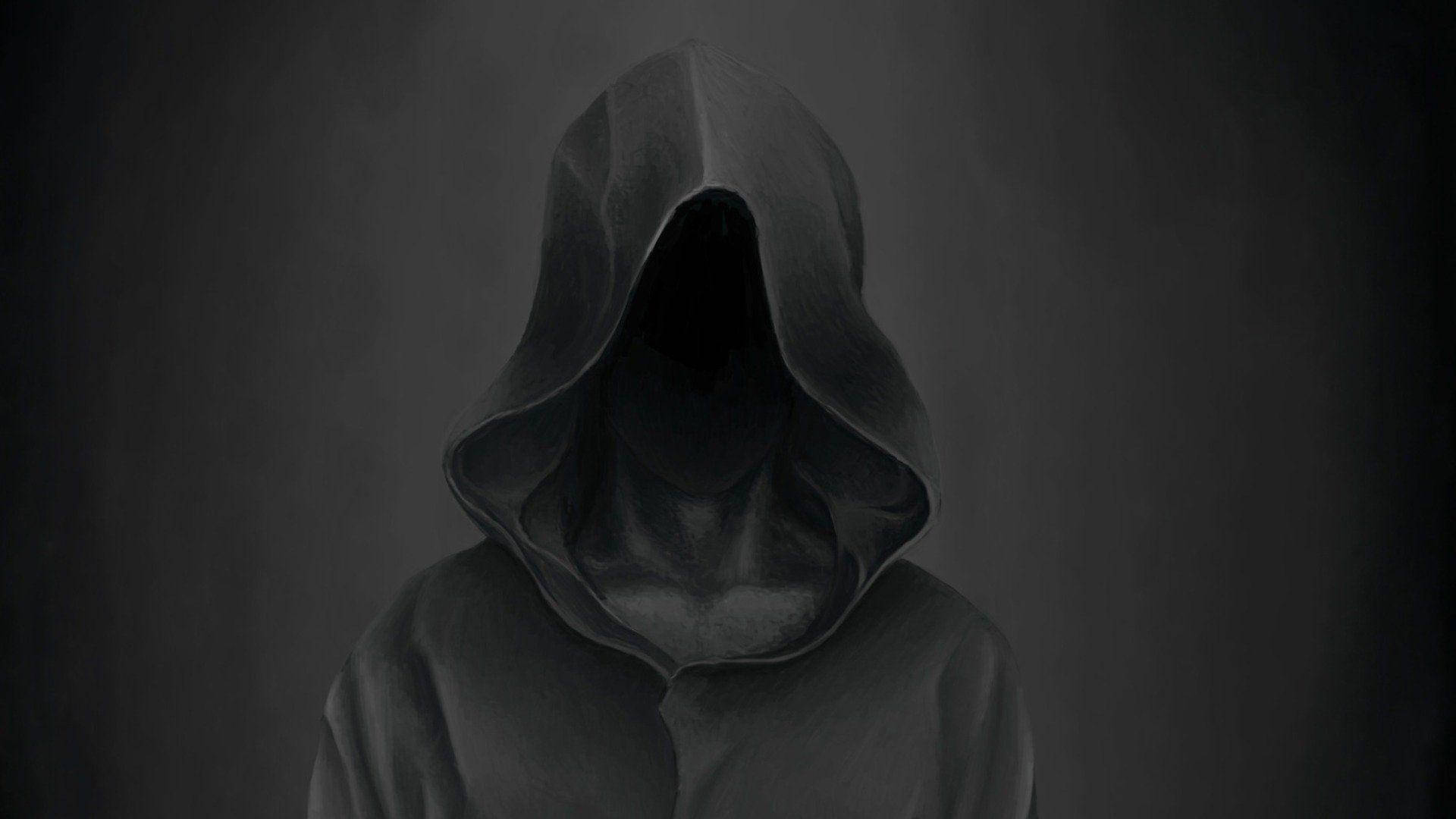 詭異的GIF 桌布 壁紙 — 一個陰暗的連帽身影在柔和的灰色背景下靜止不動，臉部隱藏在深深的黑暗中。