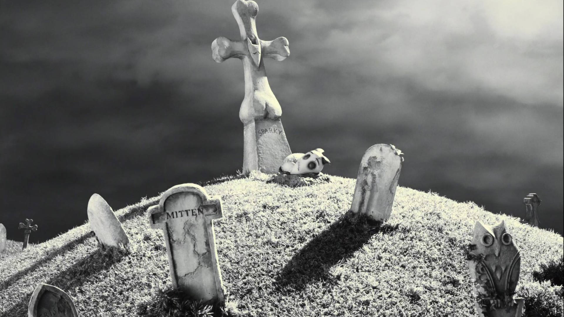 Frankenweenie 桌布 壁紙 — 一個陰森森的墓地山坡，有風化的墓碑和一個扭曲的十字架，在陰暗多雲的天空下。
