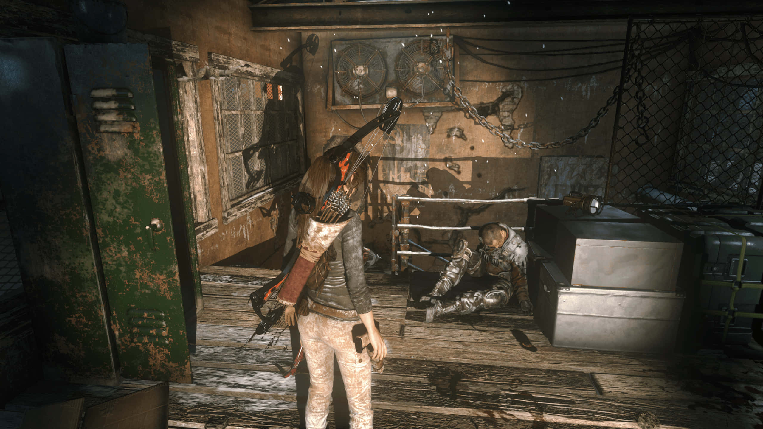 1440p Shadow Of The Tomb Raider 桌布 壁紙 — 一個陰沉的殭屍末日倖存者在生鏽的工業房間裡拿著電鋸，面對倒下的敵人。