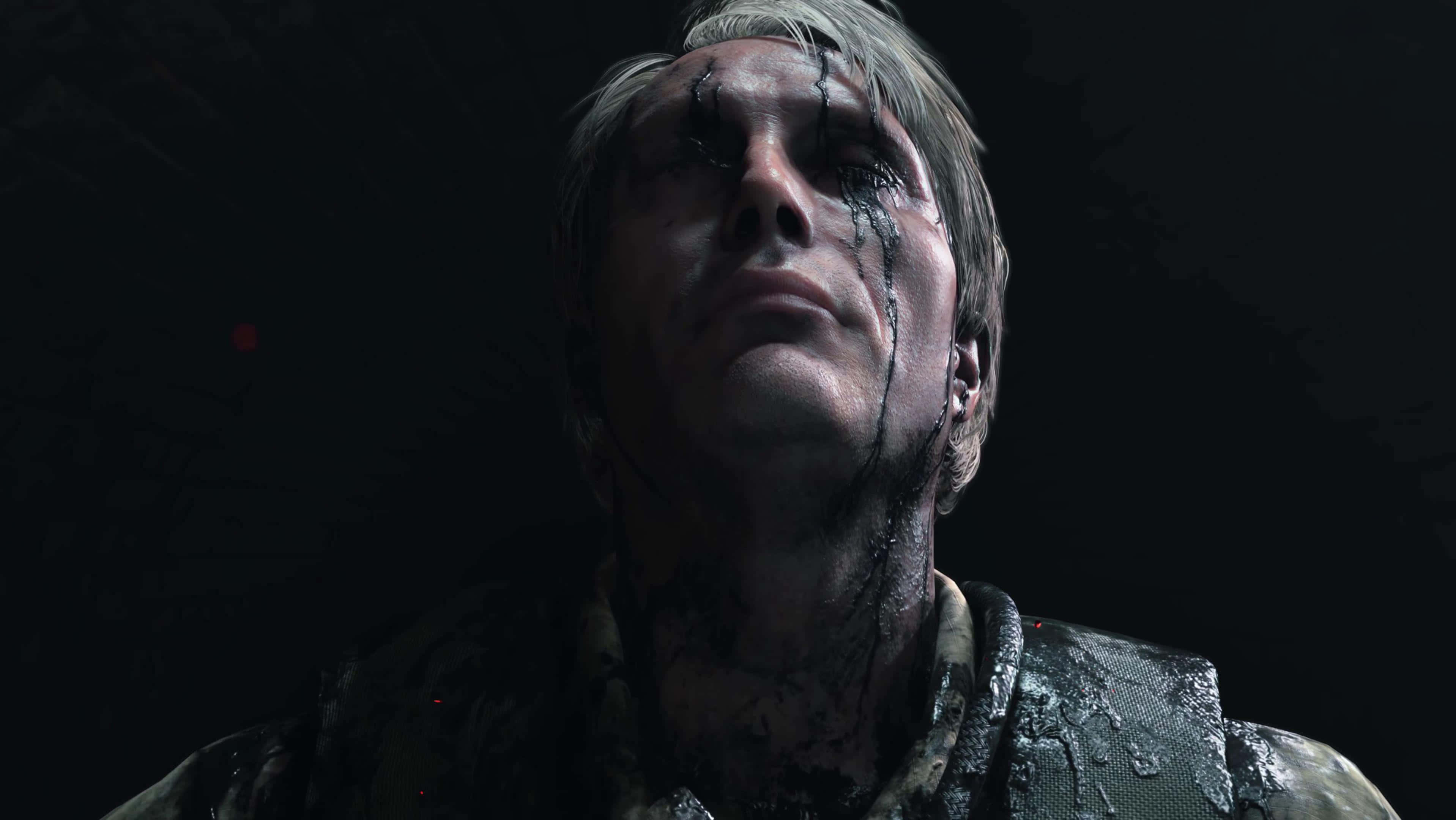 Death Stranding Desktop 桌布 壁紙 — 一個陰沉的特寫鏡頭，一個男人臉上流著血，背景是黑暗的。