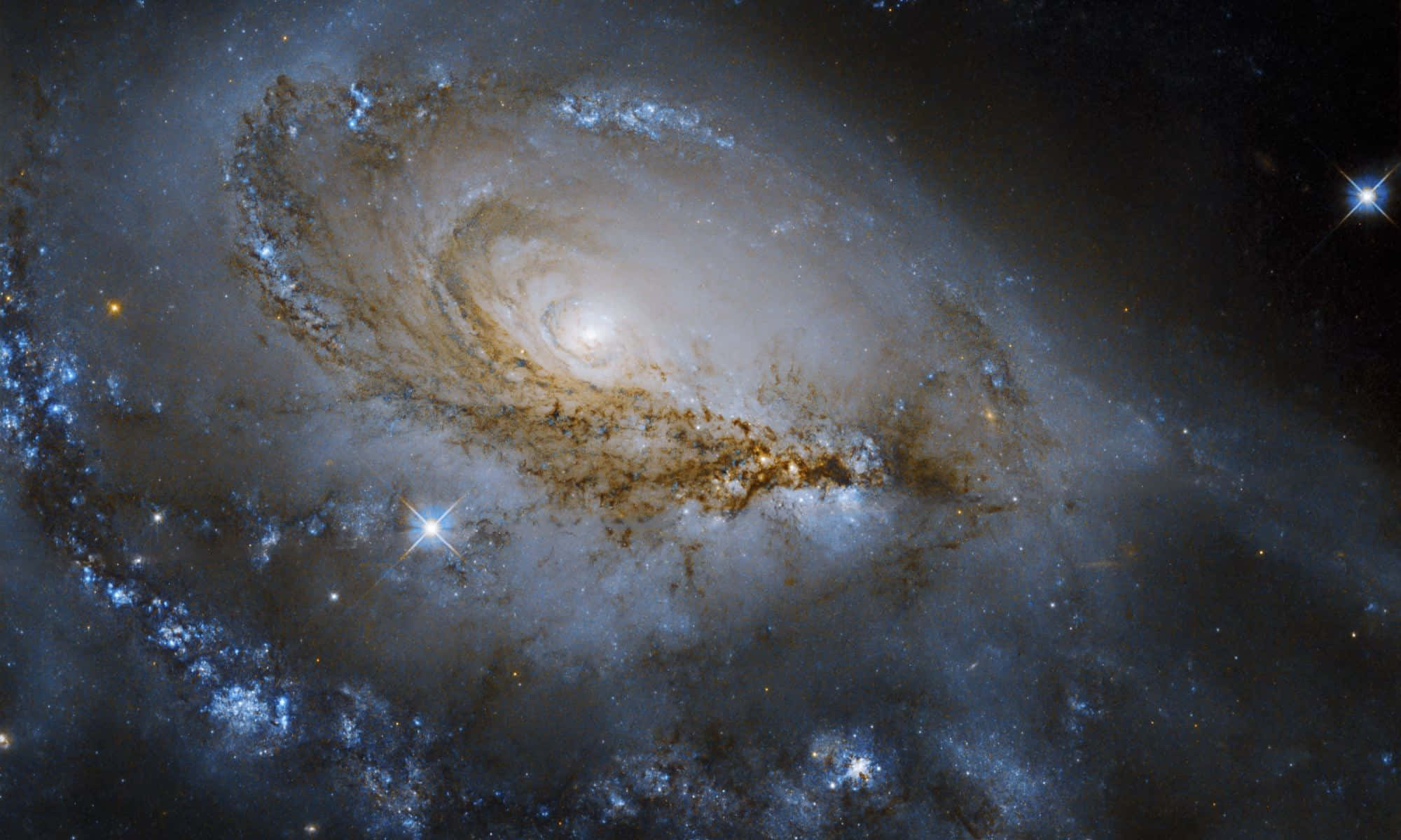 Black Hole Hubble Telescope 桌布 壁紙 — 一個雄偉的螺旋星系，其發光的藍色和金色塵埃臂在佈滿星辰的宇宙虛空中旋轉。