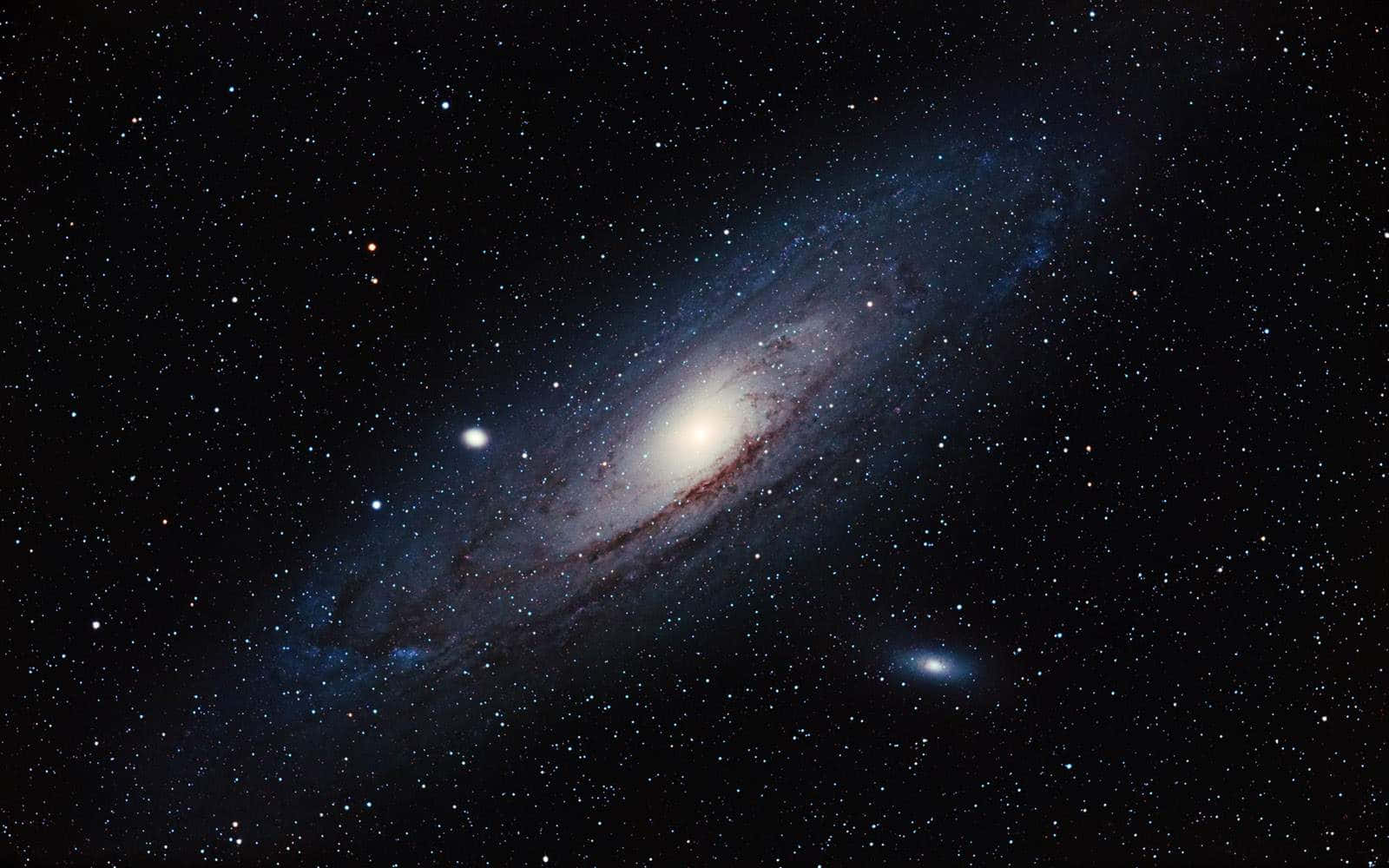 Whirlpool Galaxy 桌布 壁紙 — 一個雄偉的螺旋星系在佈滿星辰的宇宙虛空中散發出藍色和白色的色調。
