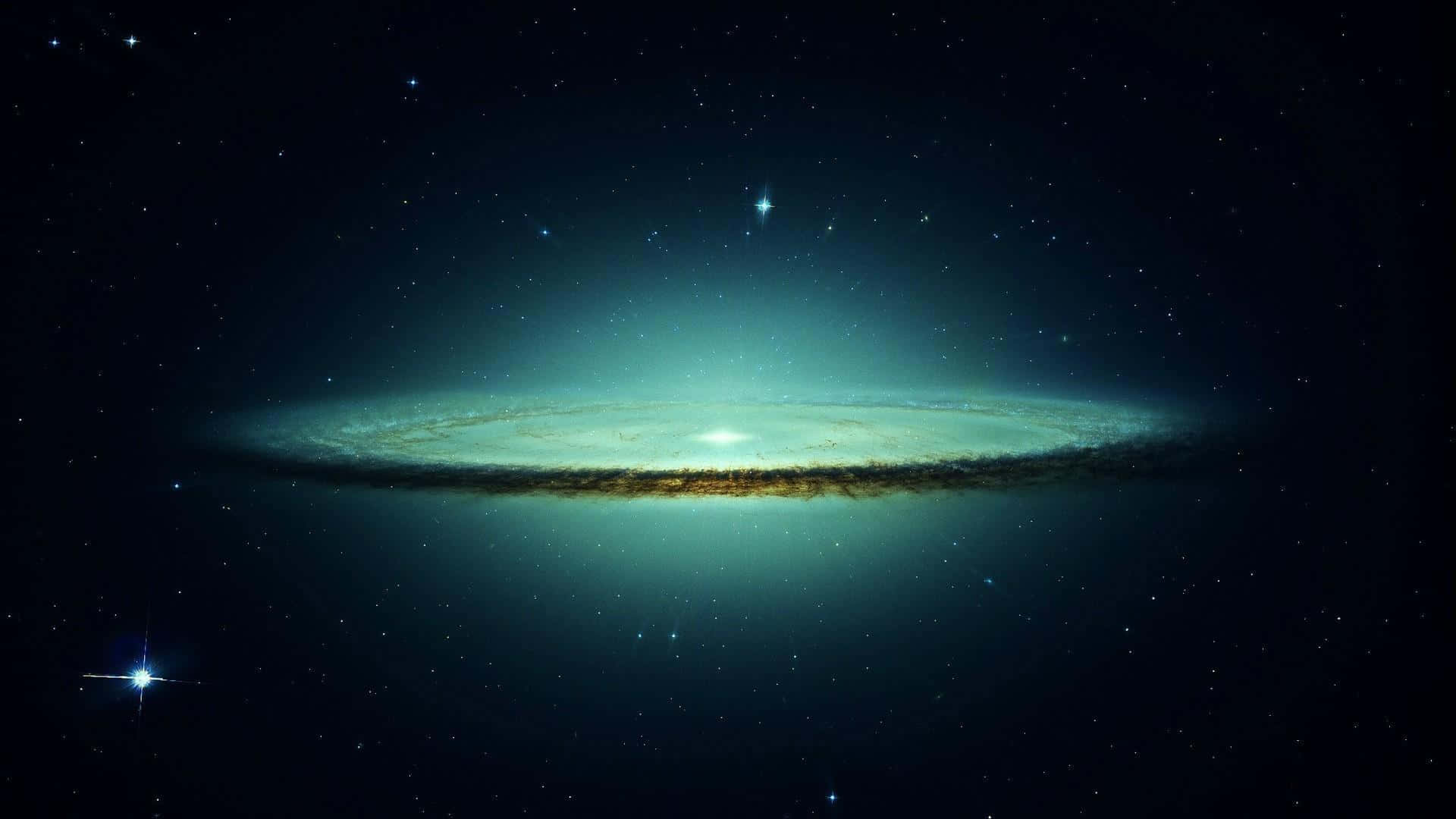 Green Galaxy 桌布 壁紙 — 一個雄偉的螺旋星系在宇宙黑暗中，以藍綠色和金色色調在星場背景下閃耀。