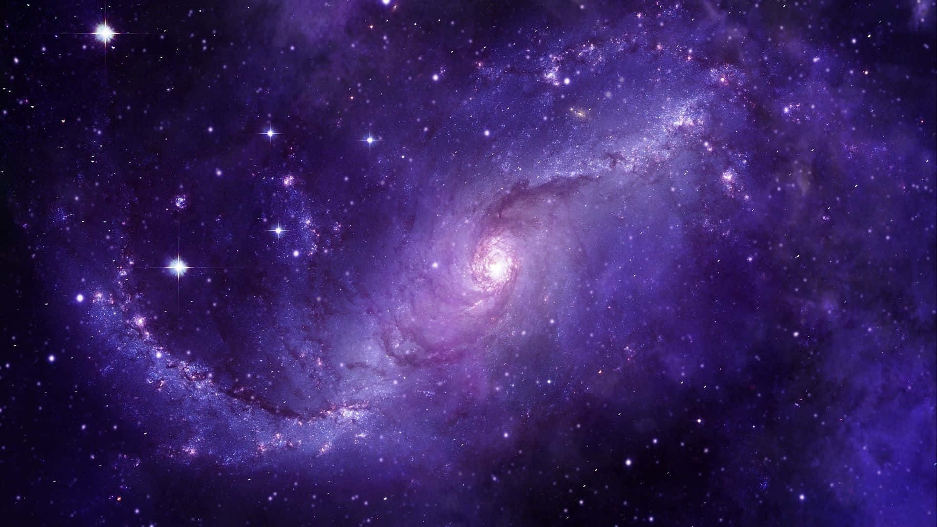 Purple Space 桌布 壁紙 — 一個雄偉的螺旋星系在深紫色和紫羅蘭色調中旋轉，在宇宙虛空中閃耀著明亮的星星。