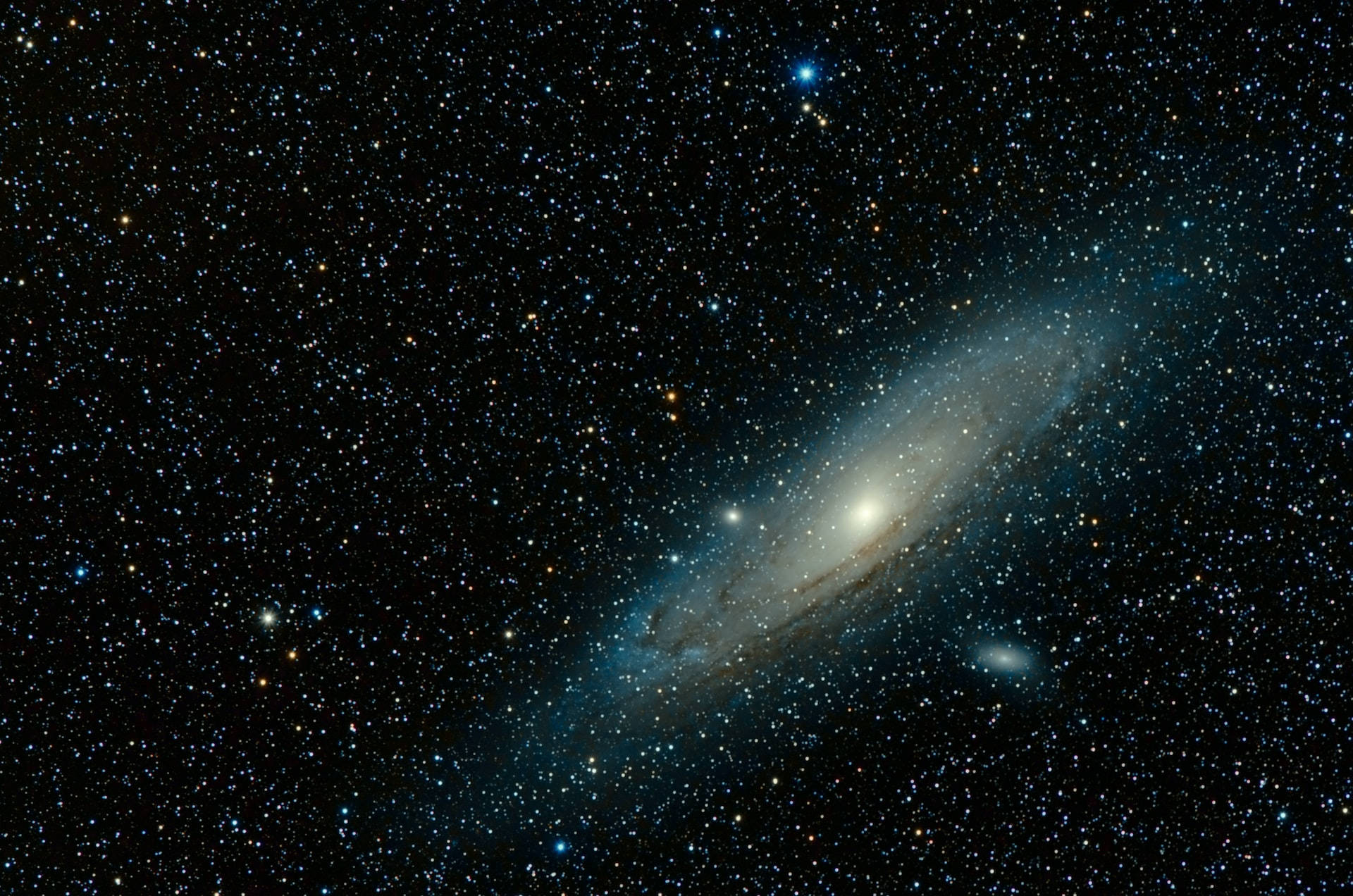 Stars 桌布 壁紙 — 一個雄偉的螺旋星系在深邃太空中無數閃爍恆星的背景下，散發著藍色和白色的光芒。