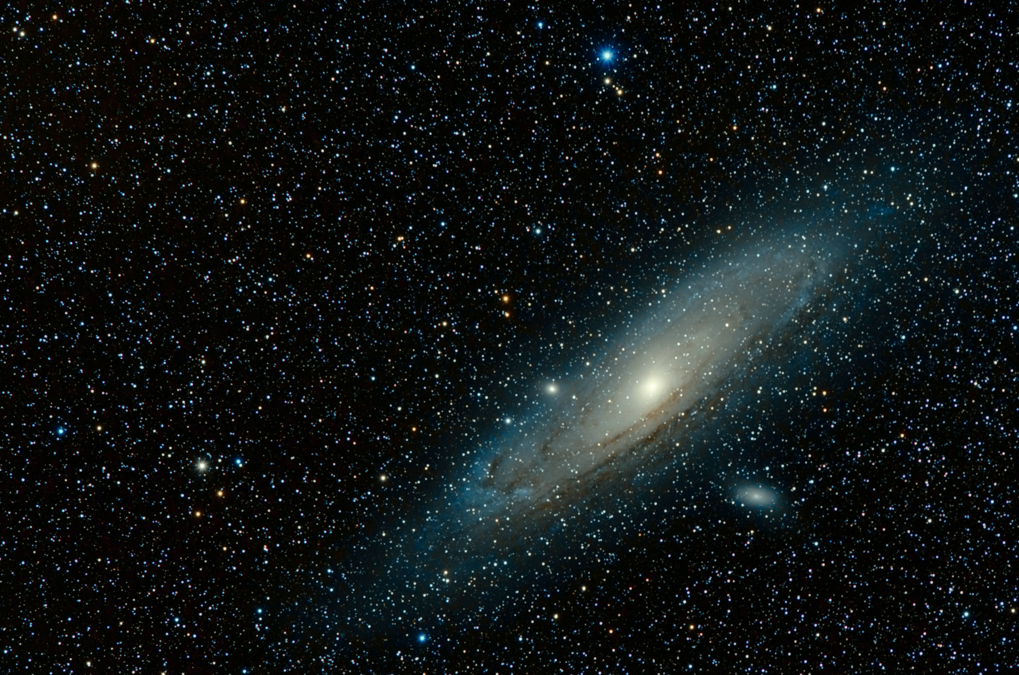 銀河 桌布 壁紙 — 一個雄偉的螺旋星系在深邃太空中無數閃爍星星的背景下發出藍色和白色的光芒。
