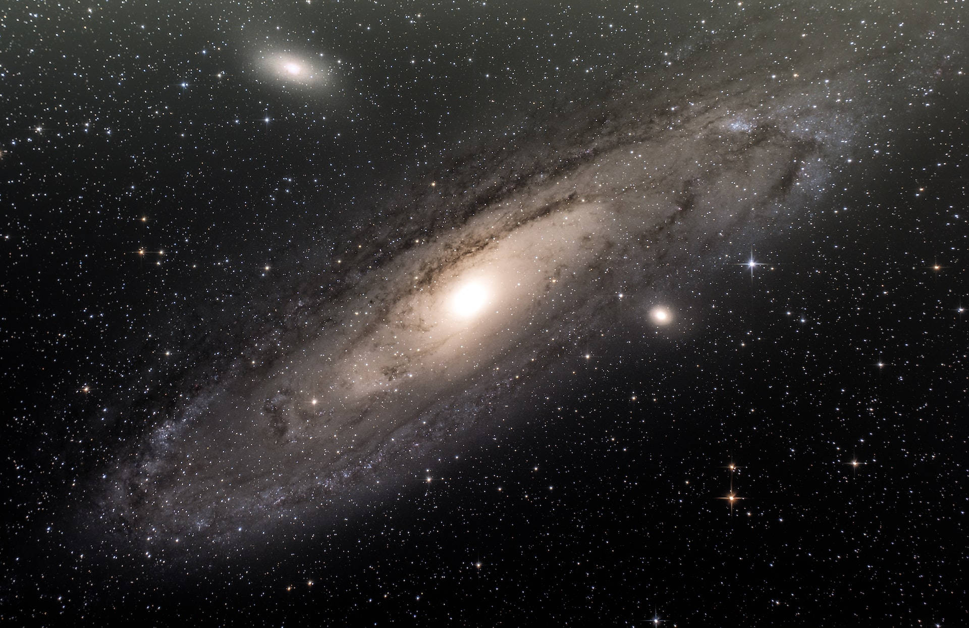 Stars 桌布 壁紙 — 一個雄偉的螺旋星系在深邃的黑色宇宙背景下，閃耀著明亮的恆星和旋轉的塵埃帶。