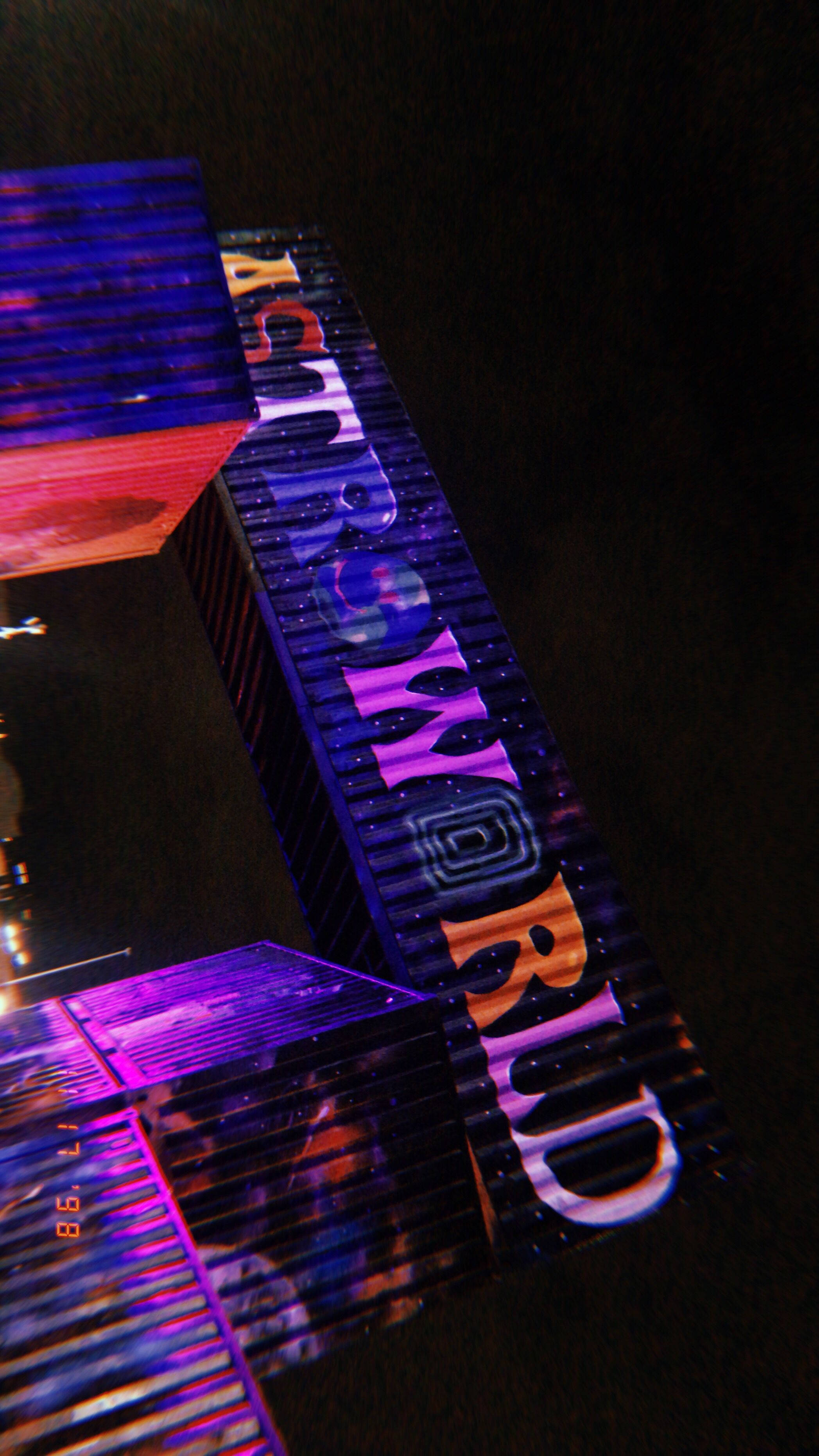 Travis Scott Astroworld 桌布 壁紙 — 一個霓虹燈 'DREAMWORLD' 標誌在黑暗的夜空中散發出充滿活力的紫色、橙色和藍色色調。