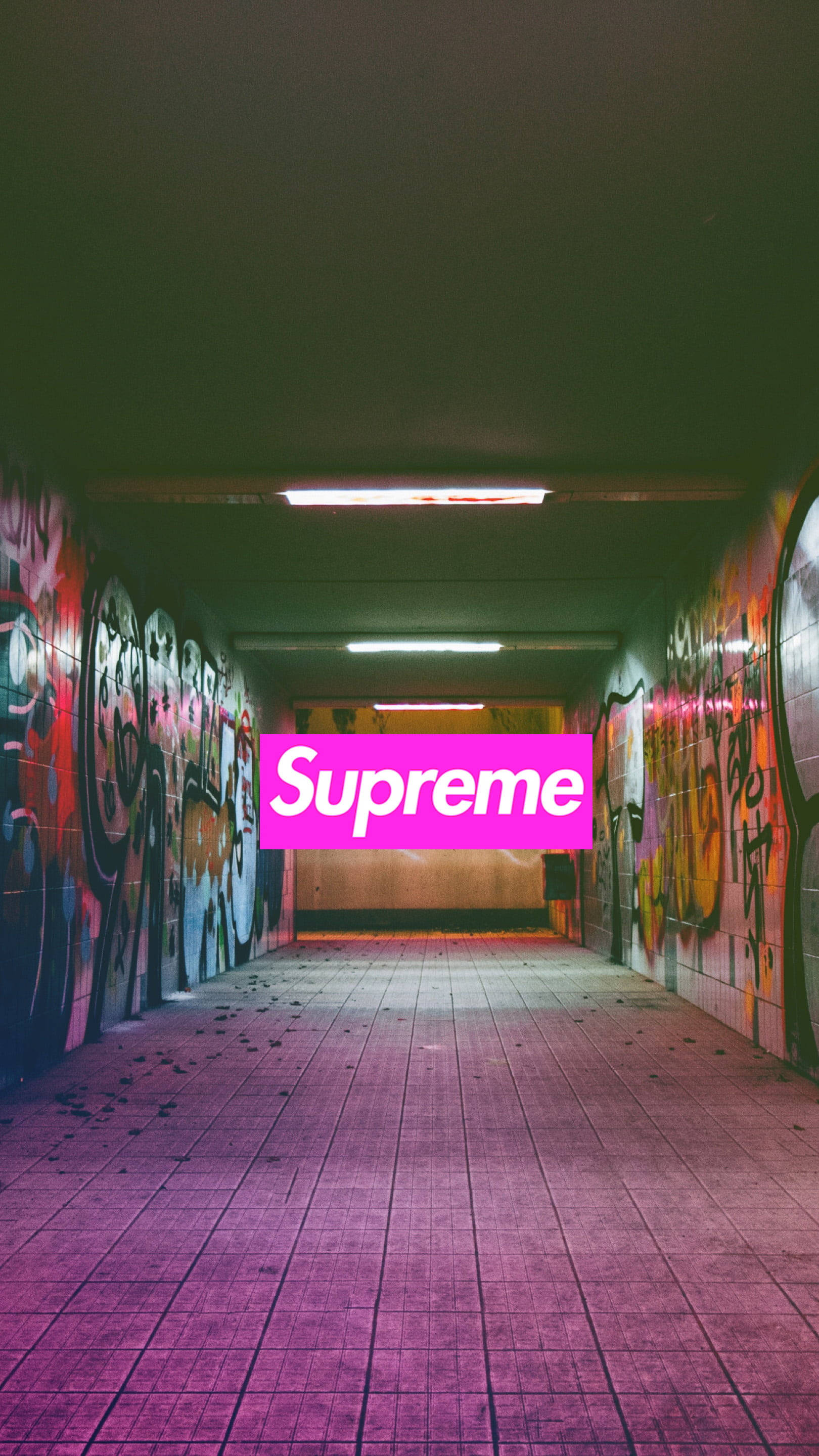 supreme 桌布 壁紙 — 一個霓虹粉紅色的Supreme標誌在一個佈滿塗鴉的城市隧道中央發光，地面鋪有紫色瓷磚，天花燈光昏暗。