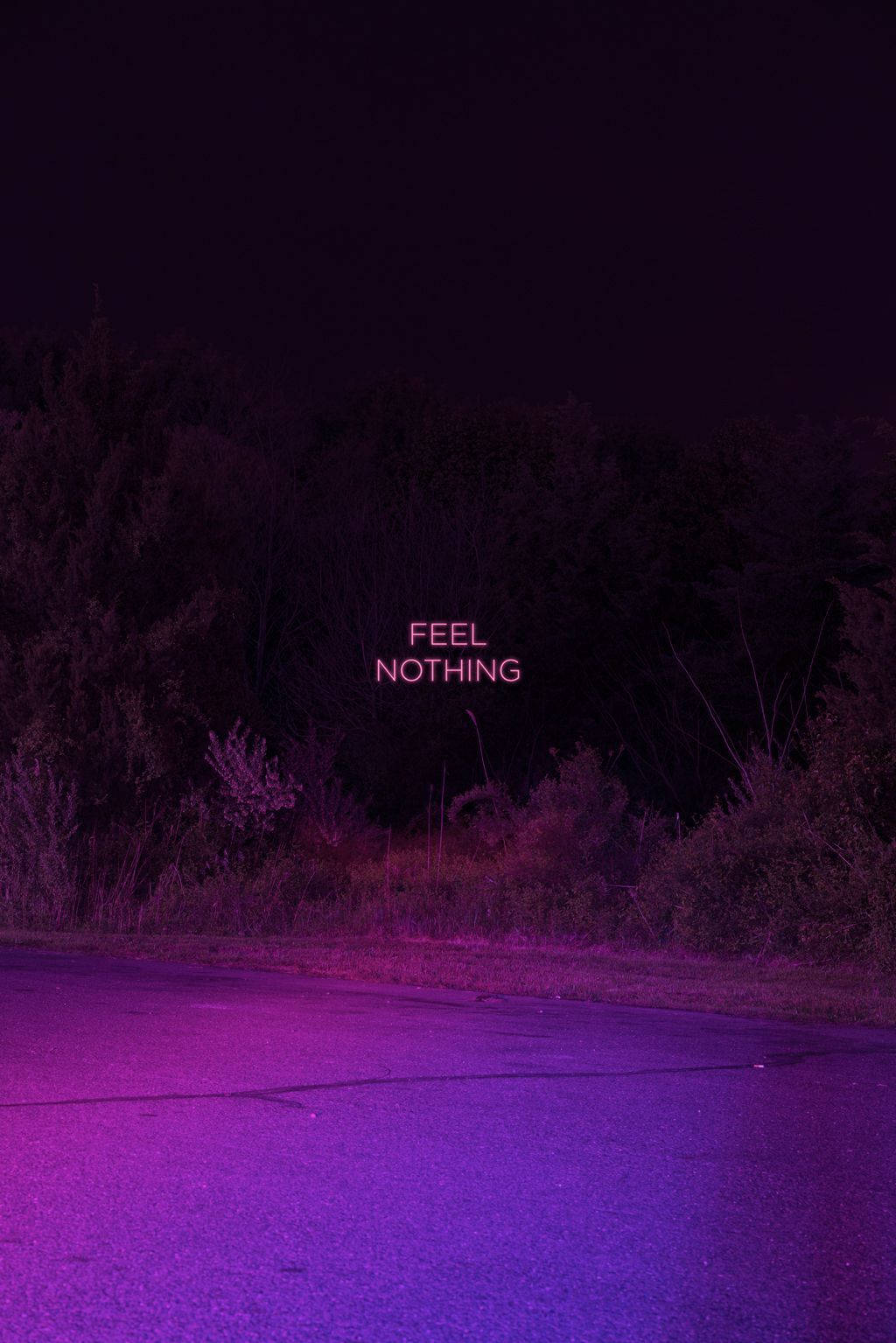 紫色美學 桌布 壁紙 — 一個霓虹粉紅色的文字寫著 feel nothing，在黑暗中的一條紫色燈光照射、樹木環繞的空曠道路上發光。