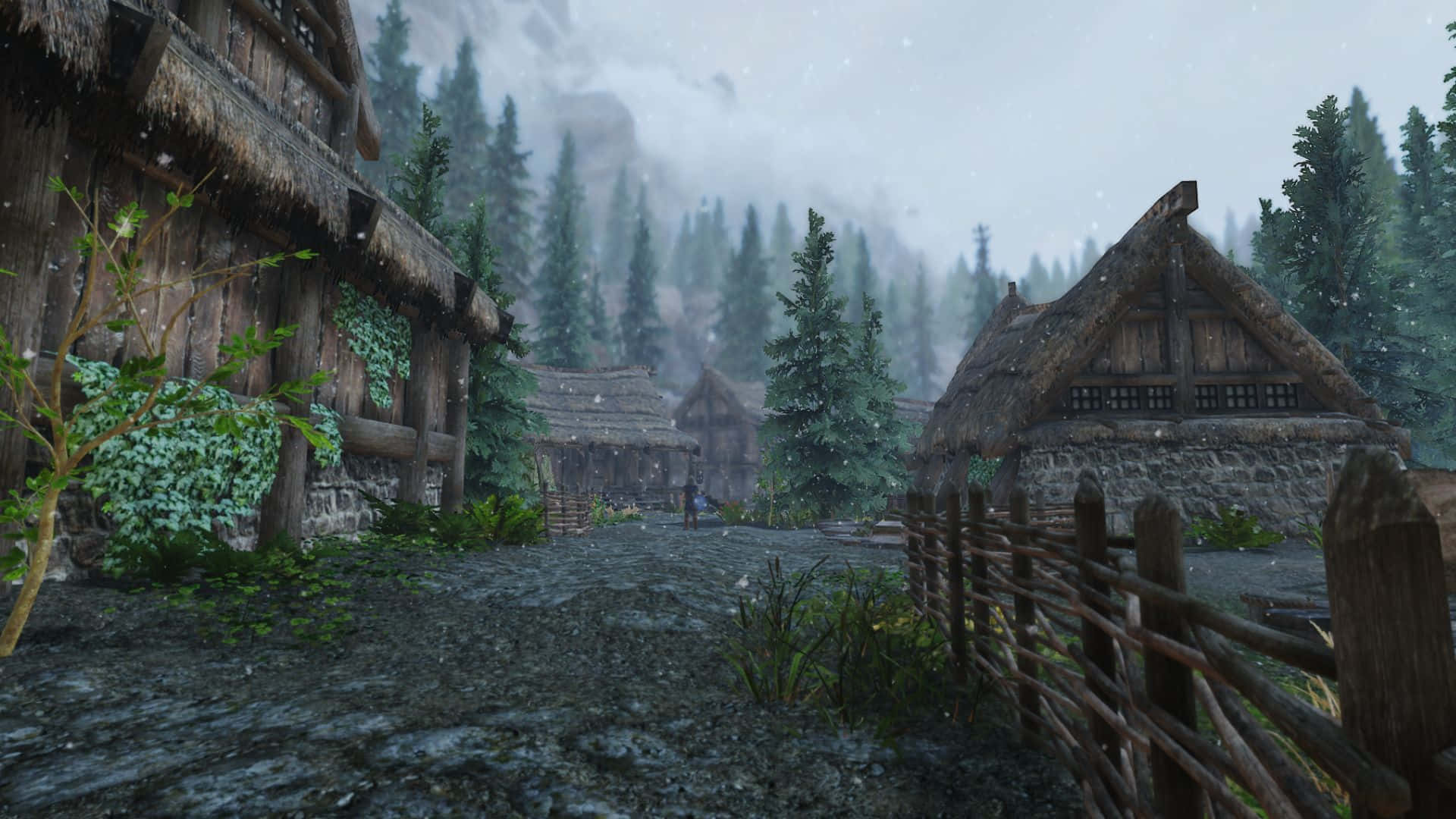 Skyrim Falkreath 桌布 壁紙 — 一個霧氣瀰漫的中世紀村莊，坐落在白雪皚皚的森林中，有茅草屋頂的小屋和石徑。