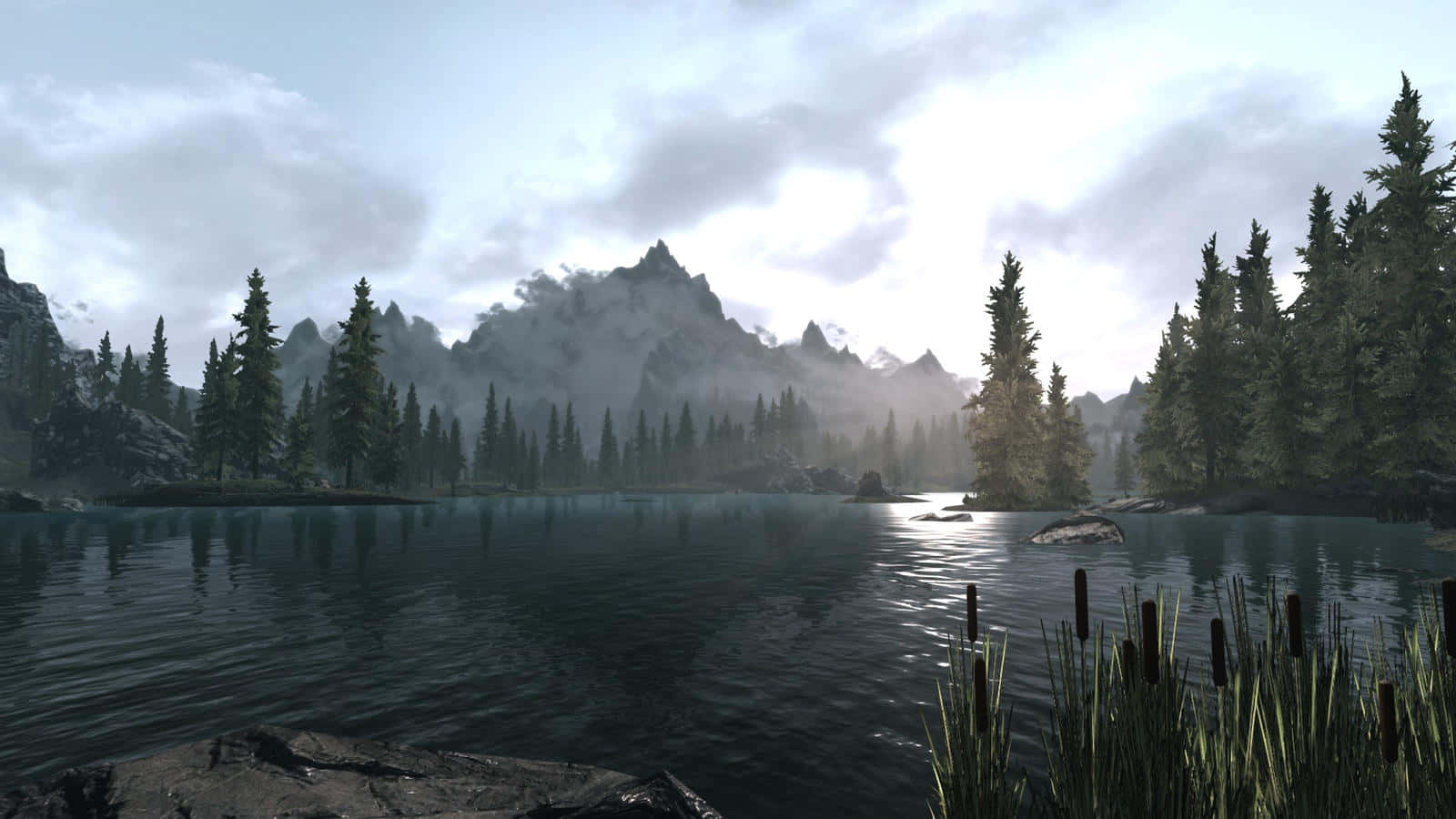 Skyrim Landscapes 桌布 壁紙 — 一個霧氣瀰漫的山中湖泊，被常綠樹環繞，天空多雲，柔和的光線映照在水面上。