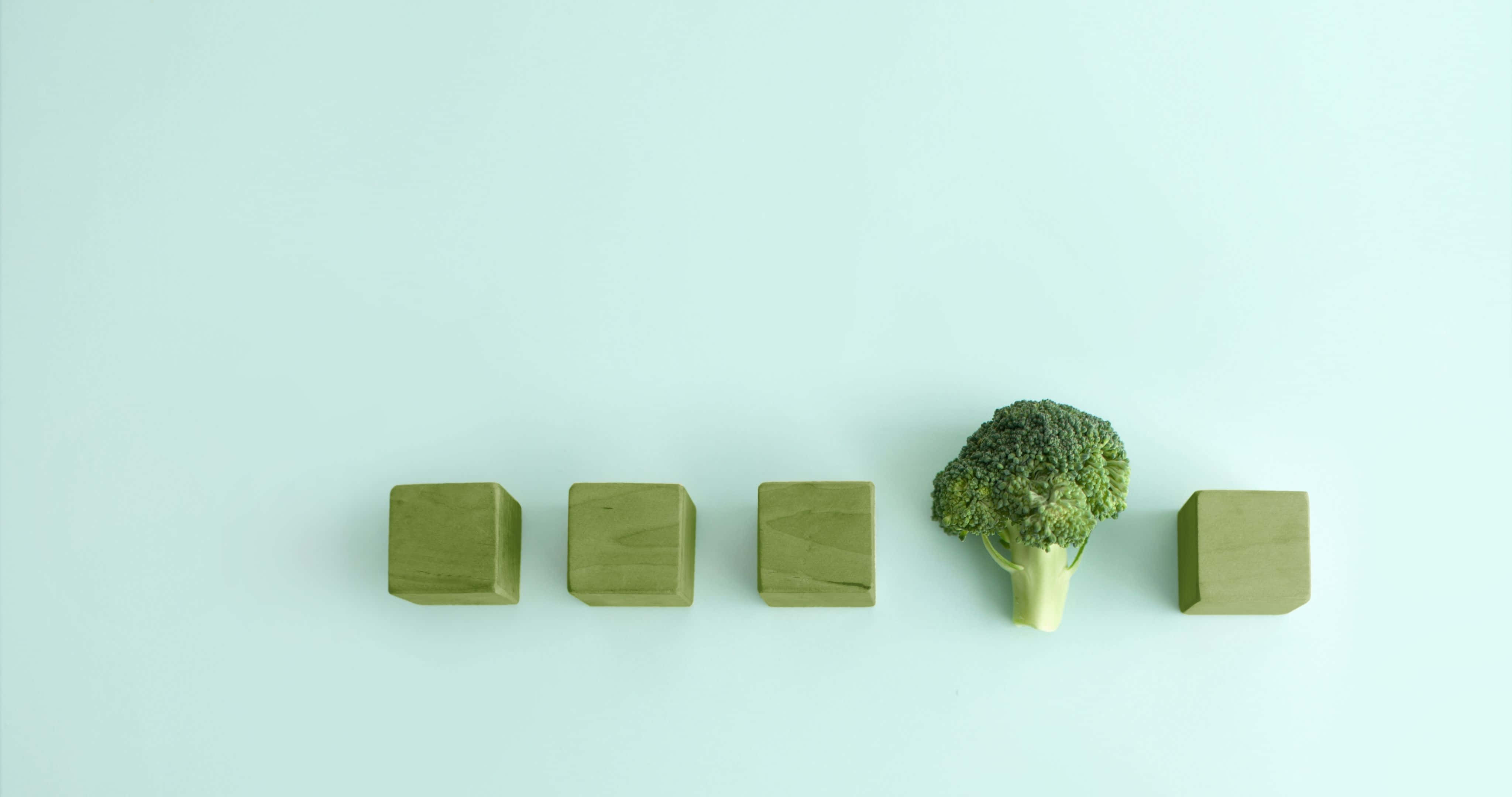 4096x2160 桌布 壁紙 — 一個青花菜小朵立在四個相同的綠色木立方體之間，背景為淡薄荷色。