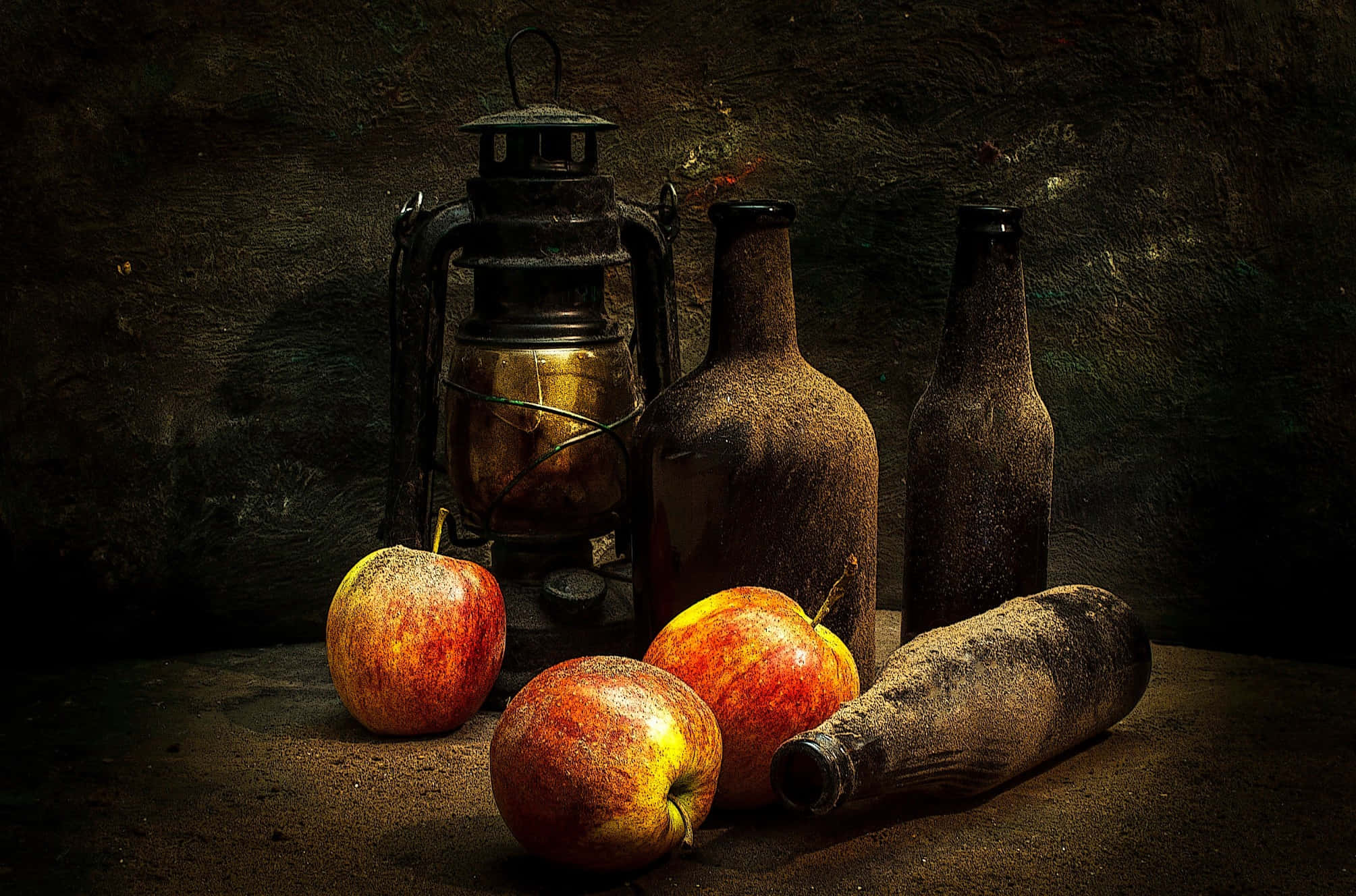 Autumn Food 桌布 壁紙 — 一個靜物畫，描繪了佈滿灰塵的蘋果和復古瓶子，被燈籠照亮，背景是粗糙的石牆。