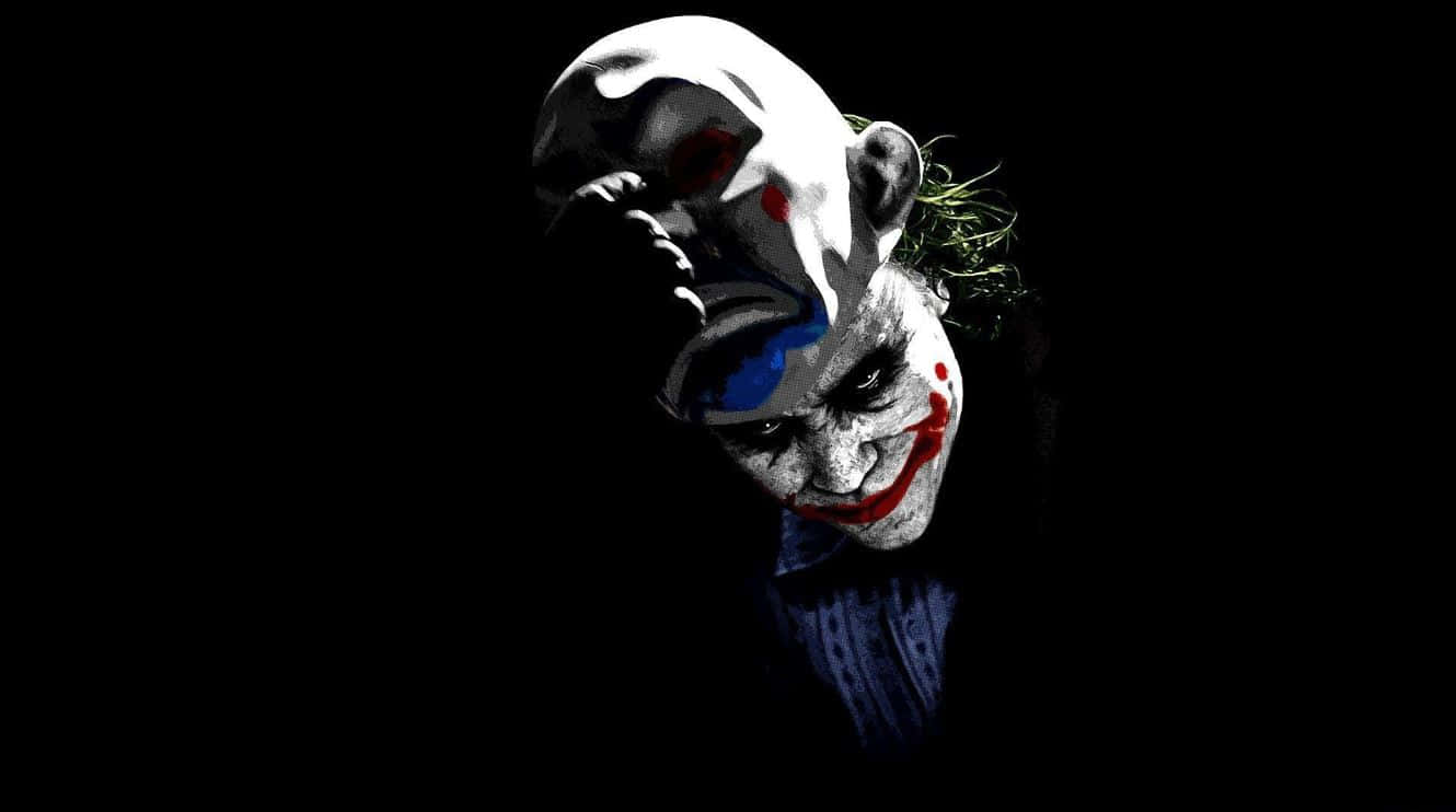 Halloween Masks 桌布 壁紙 — 一個面容分裂、化妝模糊的威脅性小丑，在黑色背景下強烈凝視。