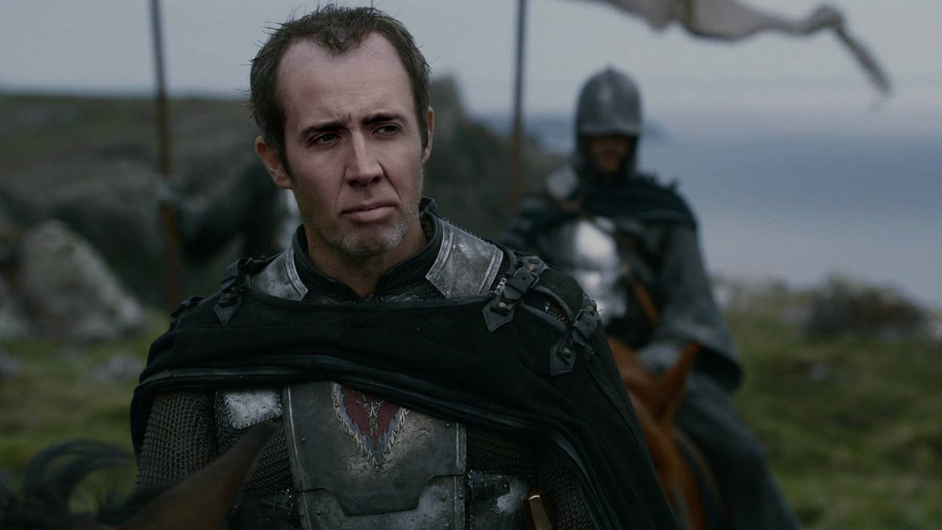 nicolas cage meme 桌布 壁紙 — 一個面容嚴峻的騎士穿著風化的盔甲，站在霧氣瀰漫的海岸懸崖上，身後還有另一個騎著馬的裝甲騎手。