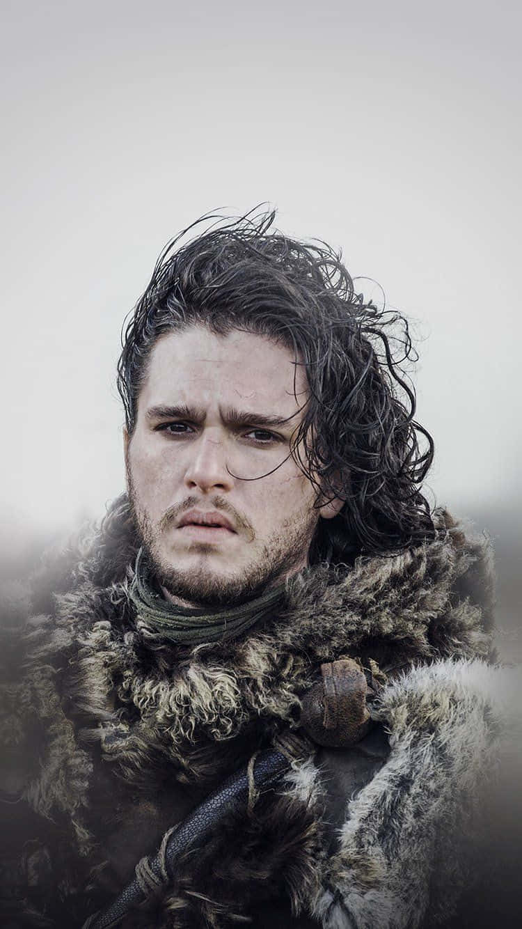 Game Of Thrones iPhone 桌布 壁紙 — 一個面容嚴肅的男人，濕透的黑髮和毛皮襯裡斗篷，在陰沉的灰色背景下強烈凝視。