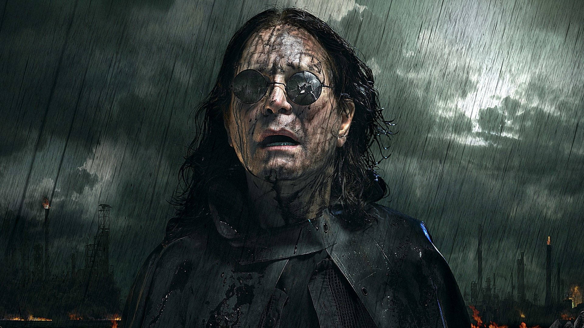 Ozzy Osbourne 桌布 壁紙 — 一個面容陰沉、戴圓框眼鏡、頭髮濕透的男人，站在風雨交加的工業廢墟中，天空陰暗。