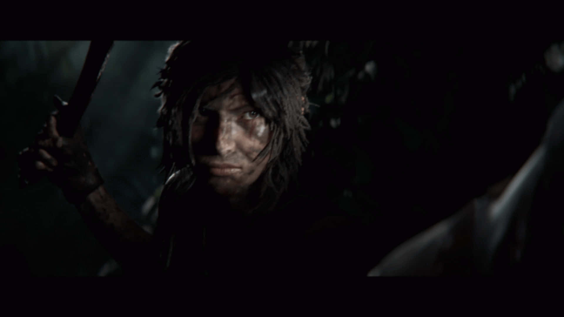 1080p Shadow Of The Tomb Raider 桌布 壁紙 — 一個面容陰沉、頭髮蓬亂的戰士，在光線昏暗、陰影重重的森林空地中緊握武器。
