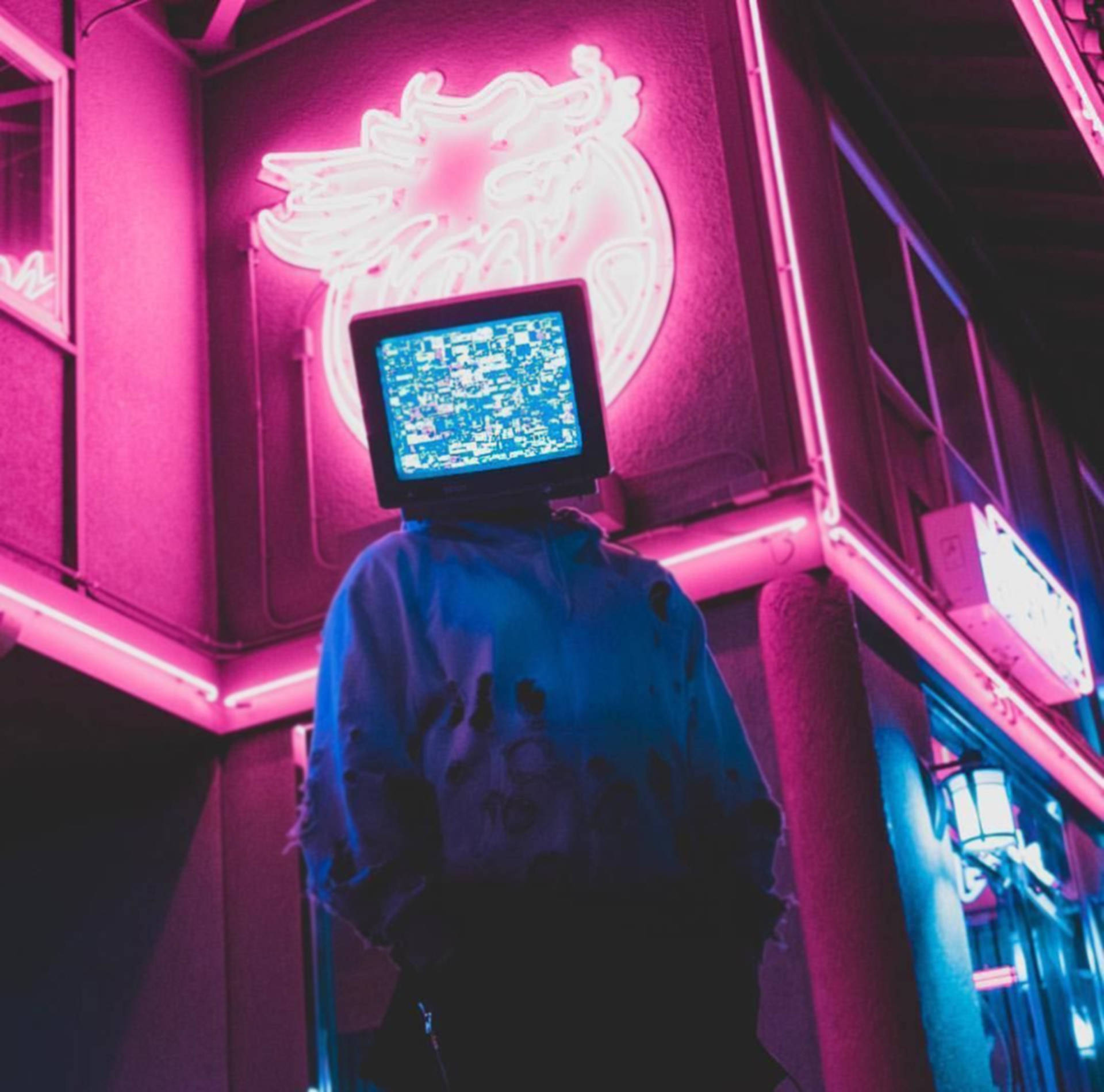 tv 桌布 壁紙 — 一個頭部為故障電視的人站在霓虹燈小巷中，下方有發光的龍標誌。