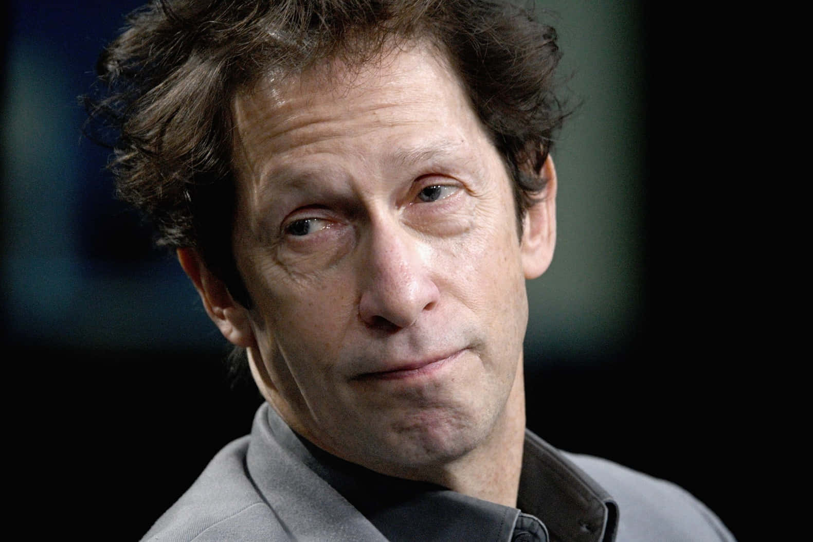 Tim Blake Nelson 桌布 壁紙 — 一個頭髮凌亂的棕色頭髮、表情深思熟慮的男士特寫肖像，背景為黑暗模糊。