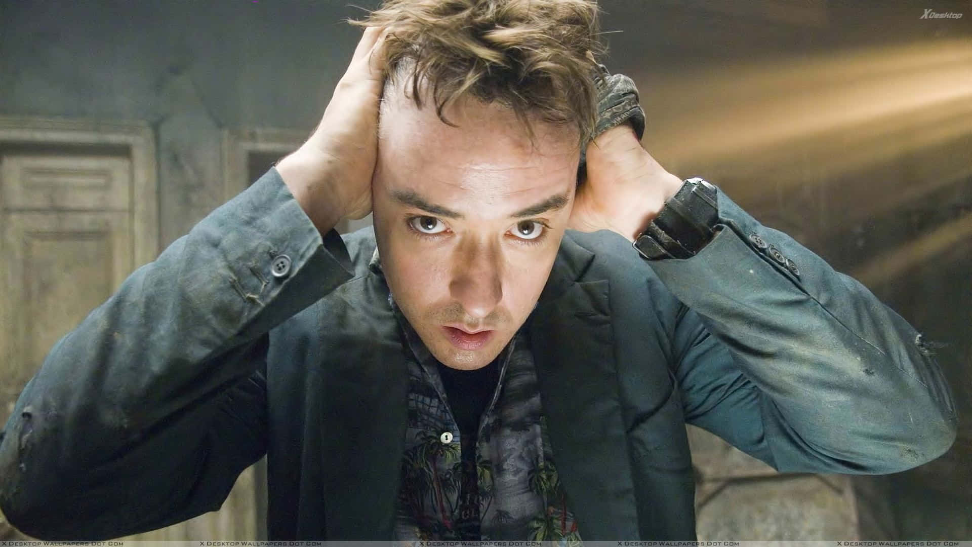 John Cusack 桌布 壁紙 — 一個頭髮凌亂的男人在昏暗的石牆上痛苦地抓著頭。