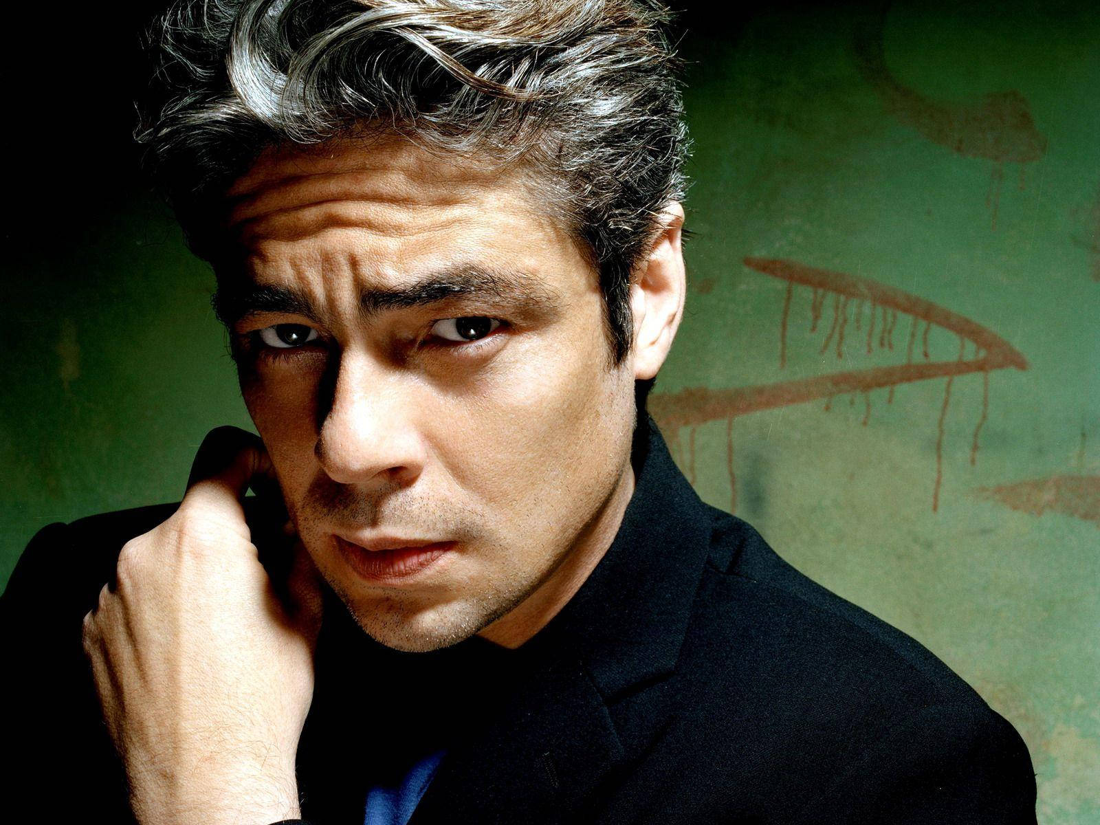 actor 桌布 壁紙 — 一個頭髮灰白、眼神銳利的男人，將手放在臉頰上，靠著一面有紅色塗鴉的紋理綠色牆壁。